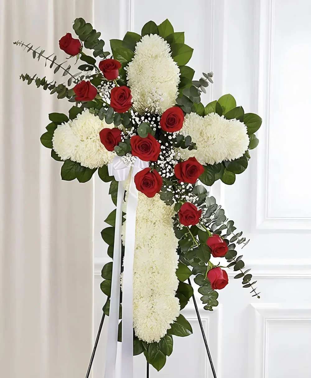 Cross White & Red Cross White & Red - This cross-shaped arrangement offers a graceful symbol of faith and remembrance. Designed with fresh blooms, it brings comfort and hope during times of loss. Placed on an easel, it stands as a heartfelt tribute.
