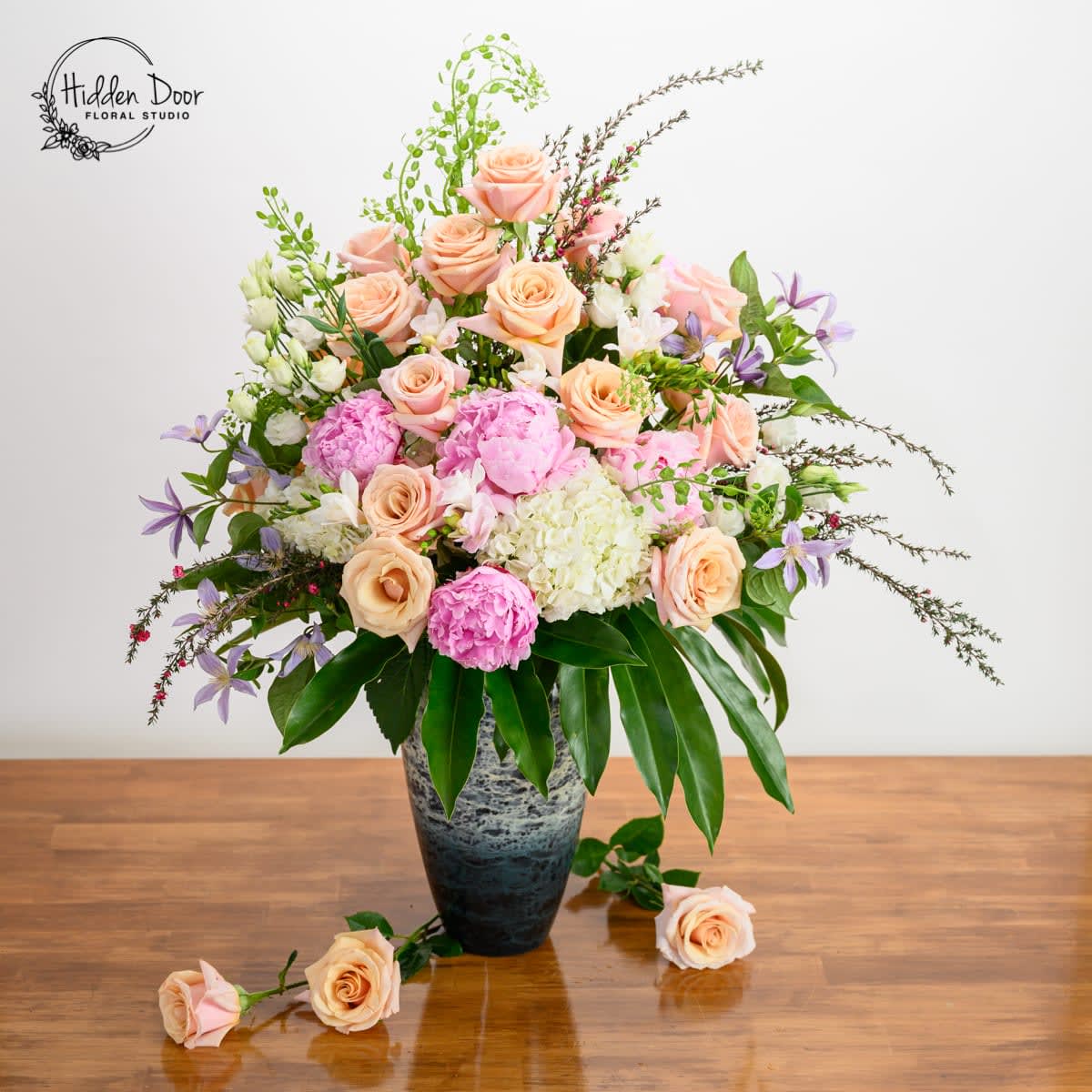 Magical Garden - Elegant, tall floral arrangement in a glazed vase. 