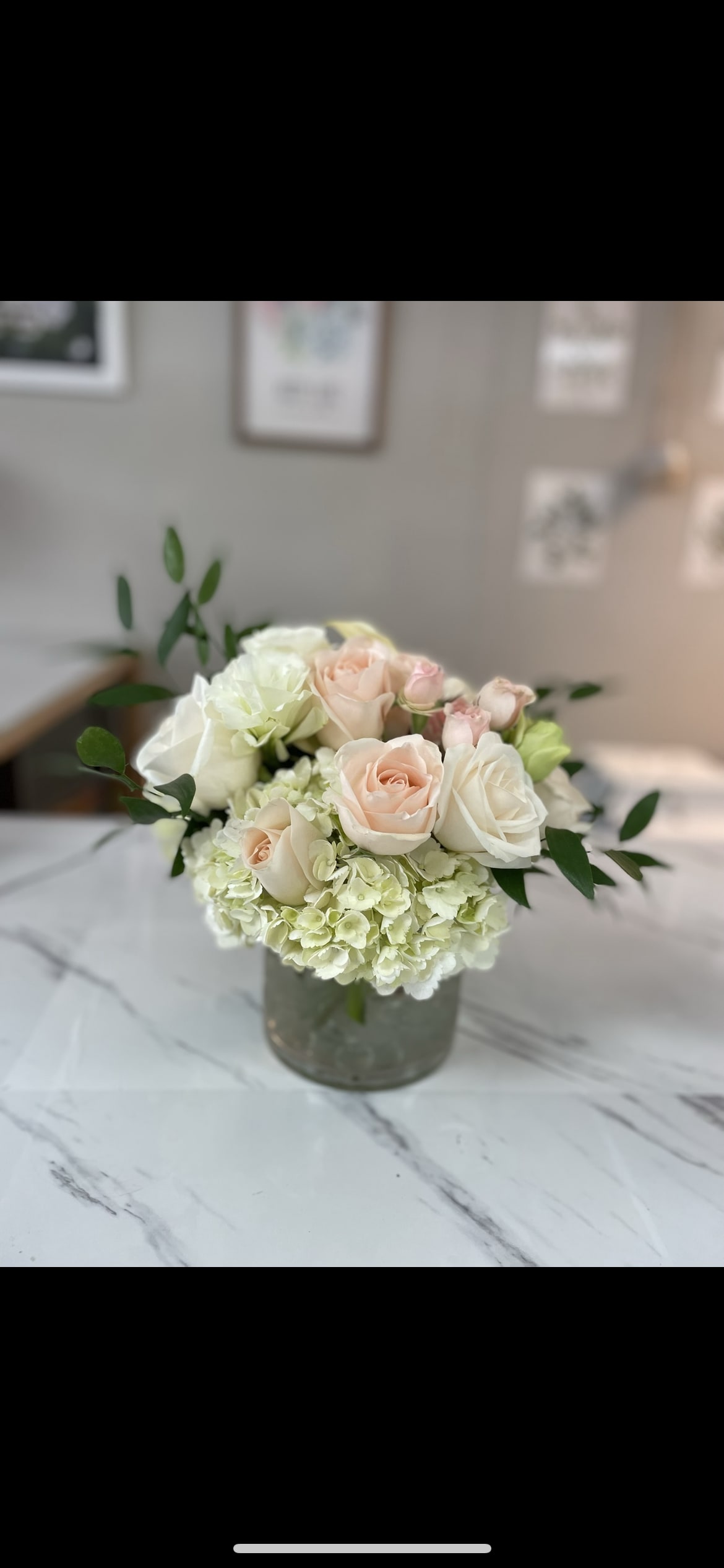 Blushing  - Our large and sleek cylinder clear vase filled with white hydrangea blush and Ivory roses.