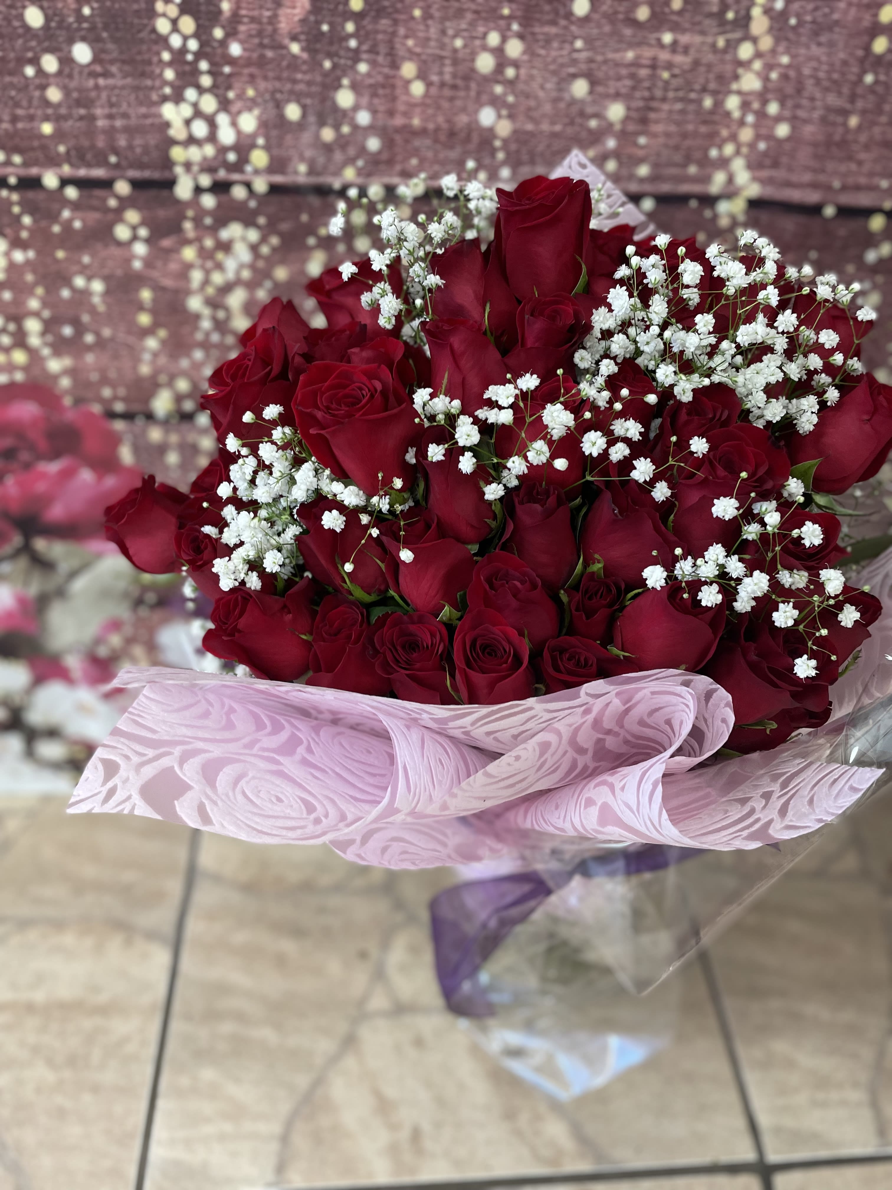 50 Red Wrapped - 50 premium long stem red roses wrapped to perfection with babies breath and greens