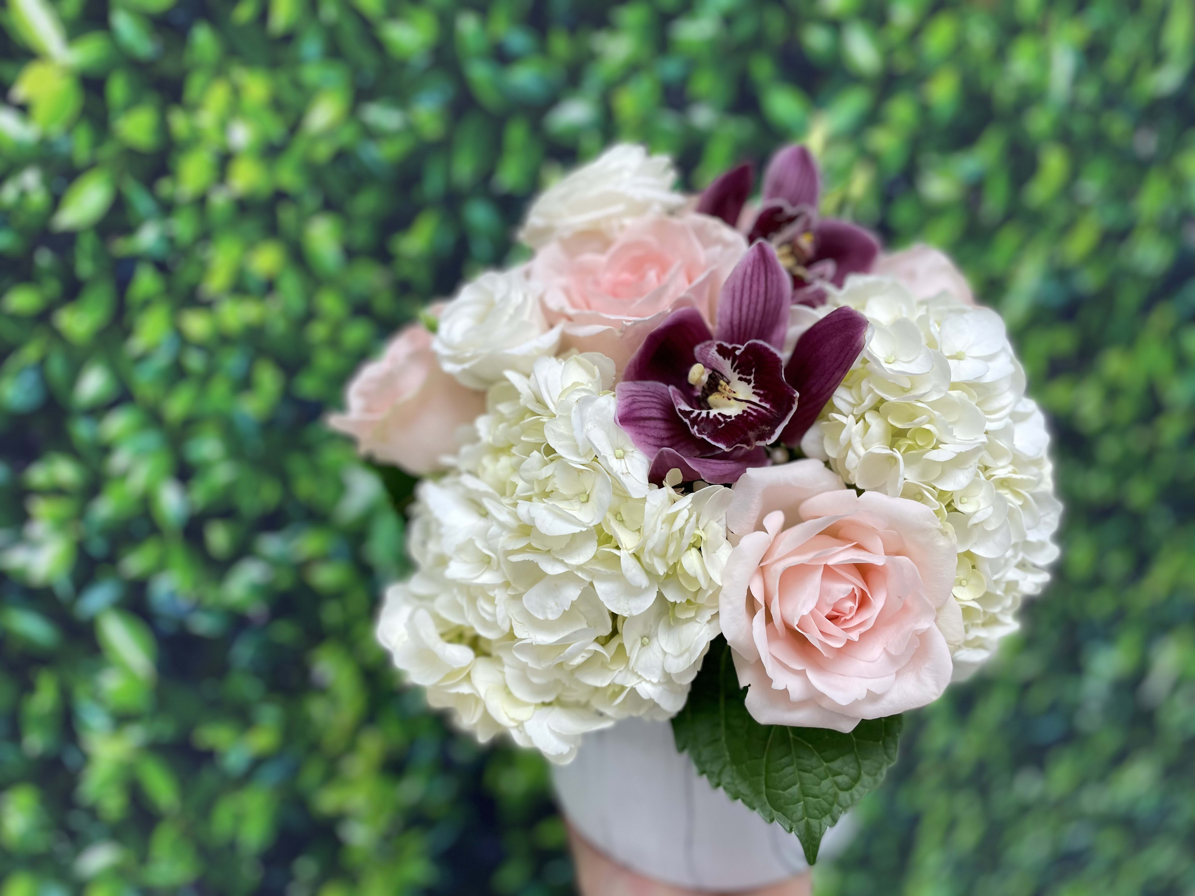 Dashing buds - A stunning marble cylinder vase with premium white hydrangea a blush roses and hot pink cymbidium orchids