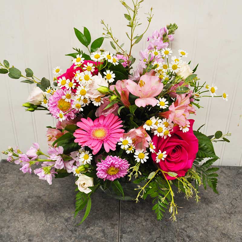 K015  Tickled Pink - Tickled Pink is a heartfelt gift perfect for expressing love and appreciation. This enchanting arrangement features light pink roses, lisianthus, stock, and germinis in a charming glass bubble bowl. Its sweet, compact design radiates elegance and warmth. While blooms may vary slightly due to seasonality, each piece retains its beauty. At Kiko's, we create unique designs that captivate and leave a lasting impression.        