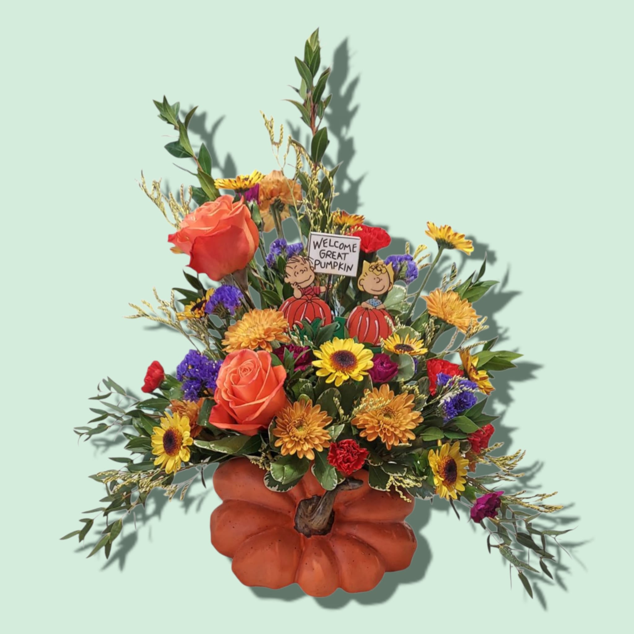 The Great Pumpkin - This adorable arrangement reminds us of the magic of the season that we felt as a child! Linus and Sally are nestled among fall colored blooms while awaiting the arrival of The Great Pumpkin.  COLORS OF FLOWERS WILL VARY WITH AVAILABILITY. Approximate size: 18&quot; H x 17&quot;W 