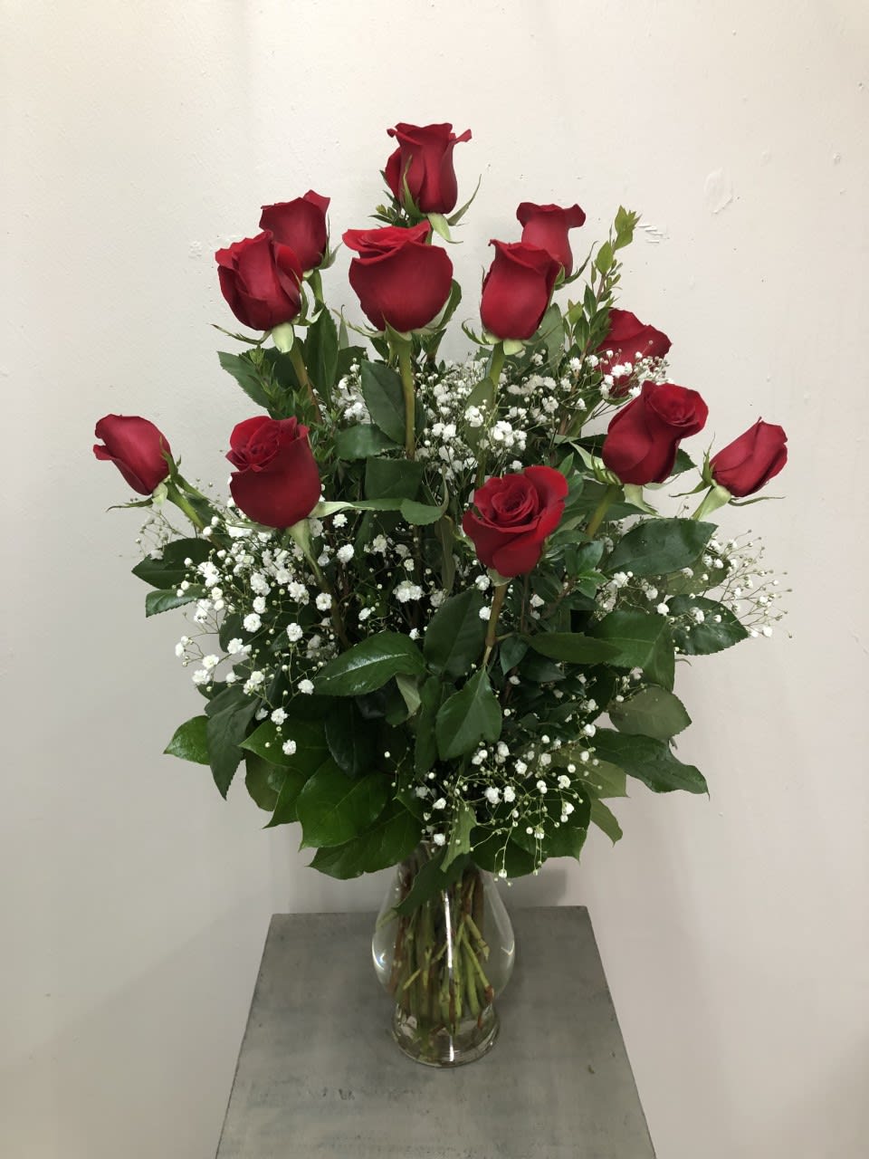 Long Stemmed Roses Arranged In A Vase (choose color) - A dozen roses arranged in a vase by our expert designers, dressed up with filler and greenery.  Picture shown shows RED, so if no preference is selected we will do red. otherwise please INCLUDE COLOR PREFERANCE FOR ROSES UNDER SPECIAL INSTRUCTIONS.  COLORS: RED, PINK, WHITE, YELLOW, MIXED COLORS  Standard: 1 dozen Deluxe: 2 dozen Premium: 3 dozen