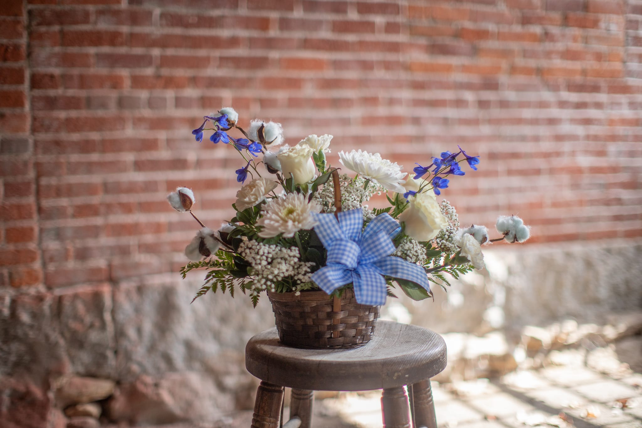 Cotton-Candy Basket (Pink or blue) - Delicate puffs of pink or blue cotton branches surround a fresh floral artwork of creamy-white blooms. Accompanying pink or blue linear floral varieties really give this woven basket arrangement presence. Prefect to welcome a little one to the world, or let someone you care about know you think they're sweet. Please be sure to specify if you would like the design in pink or blue in the special instructions. 