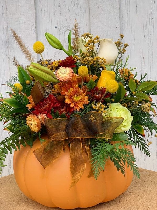 Pumpkin Centerpiece - Festive ceramic pumpkin filled with seasonal greens, berries and flowers. This pumpkin makes a great gift or a perfect holiday arrangement.