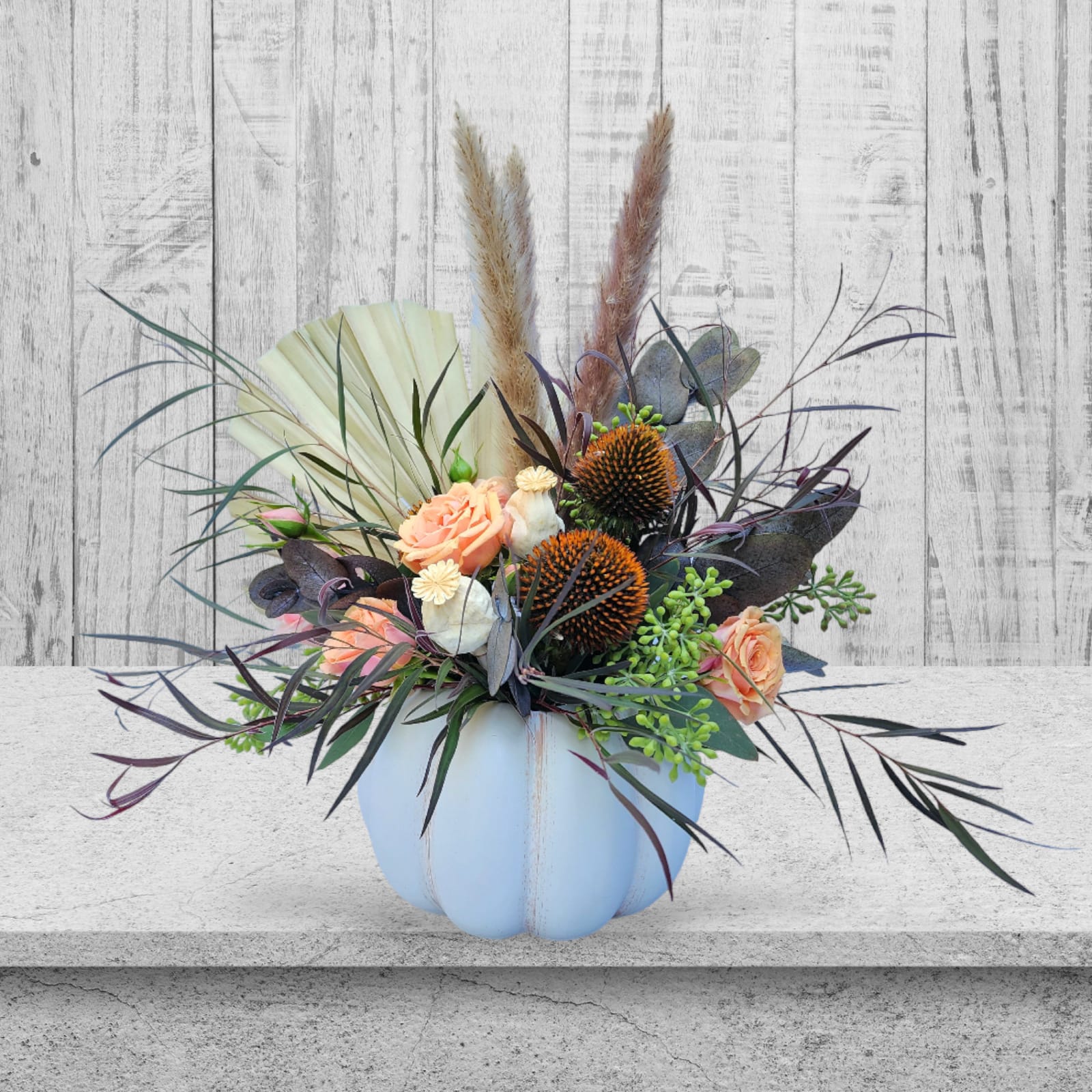 Boho Autumn Boho Autumn - Located in the heart of Olympia, our inspiration is drawn from the natural beauty that envelops us, and the 'Boho Autumn' arrangement is an authentic reflection of this eclectic mix. Meticulously handcrafted with care and creativity, it showcases a charming ceramic white pumpkin adorned with earthy brown echinacea cones, delicate dried poppy pods, and the graceful elegance of pampas grass, all harmoniously complemented by the soft, captivating hues of spray roses. This striking combination of colors, patterns, and textures beautifully captures the essence of the autumn season. Whether you're seeking to infuse a touch of whimsy into your home decor, searching for the perfect gift to enchant Halloween, or preparing for a festive Thanksgiving celebration, the 'Boho Autumn' bouquet is your ideal choice. Please be aware that the variety of flowers in our 'Boho Autumn' arrangement may shift slightly with the changing seasons, ensuring that each bouquet remains a unique work of art. At Specialty Floral Design, we take great pride in eschewing mass-produced, cookie-cutter creations. Our commitment is to offer you an authentically special and distinctive floral experience, far removed from the ordinary. As your trusted local florist, we proudly serve Olympia and extend our same-day delivery services to Tumwater, WA, and Lacey, WA. We are dedicated to spreading the sheer joy of flowers to your friends and family precisely when you need it most.