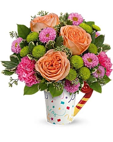 Teleflora's Time To Celebrate Bouquet Teleflora's Time To Celebrate Bouquet - Make their birthday one to remember with a surprise bouquet of radiant roses presented in a colorful, confetti-covered mug! The food-safe ceramic design will cheer them up all year long. This fun bouquet features peach roses, pink matsumoto asters, green button spray chrysanthemums, dark pink carnations, variegated pittosporum, lemon leaf and seeded eucalyptus. Delivered in a Cheers to You mug.