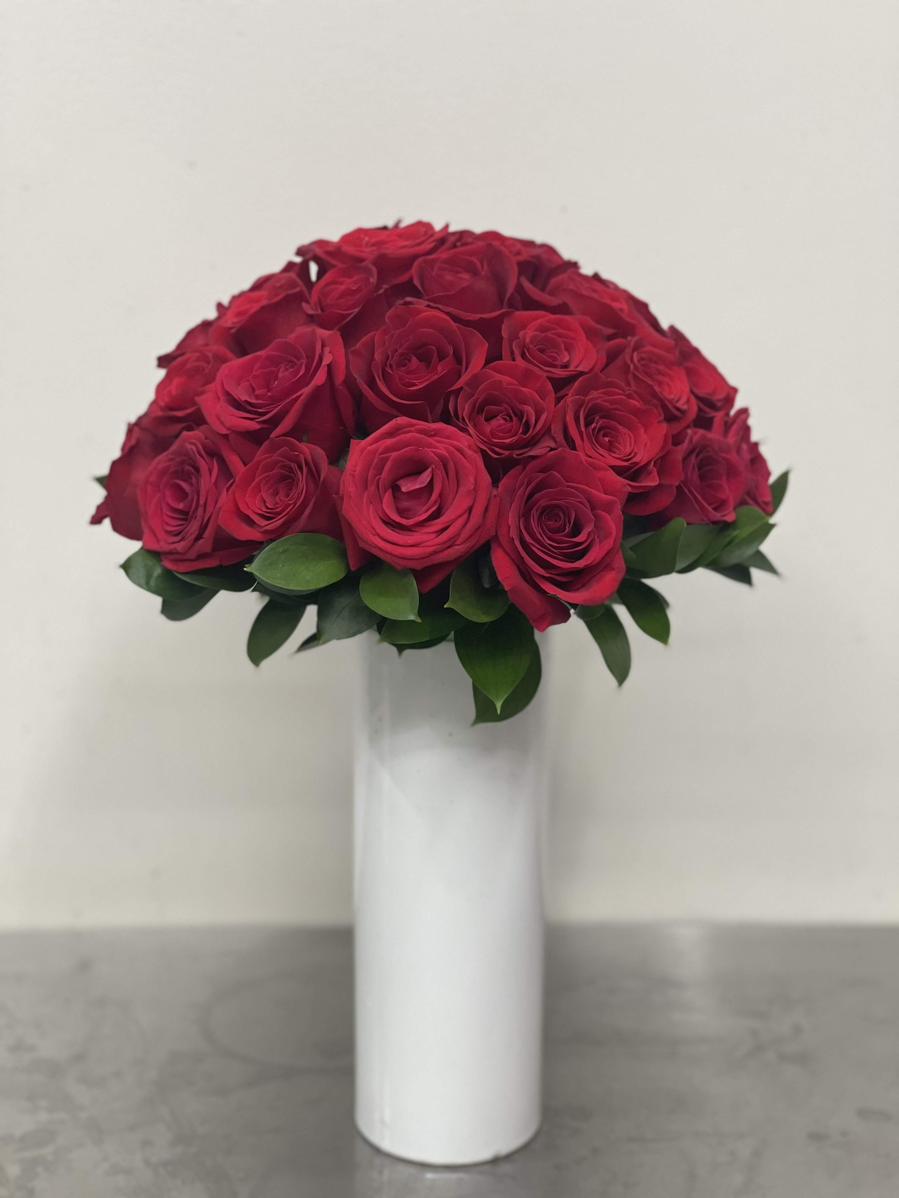 A Rose By Any Other Name - Two dozen medium stemmed roses and premium greenery in a sleek modern vase. Please specify color other than red. 