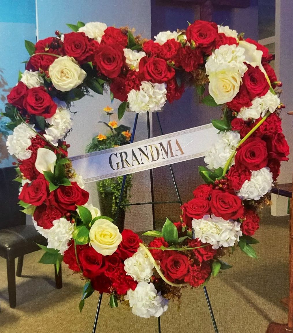 Heart HS-13 Heart HS-13 - This classic red and white heart-shaped wreath is a timeless tribute made with red roses, white hydrangea, and elegant white calla lilies. Designed to honor a beloved grandmother or cherished family member, this arrangement is a graceful addition to any memorial service. Popular for funerals in Estrella Mountain Ranch, Palm Valley, and surrounding West Valley communities. Easel stand included; ribbon personalization available for $10 per word.