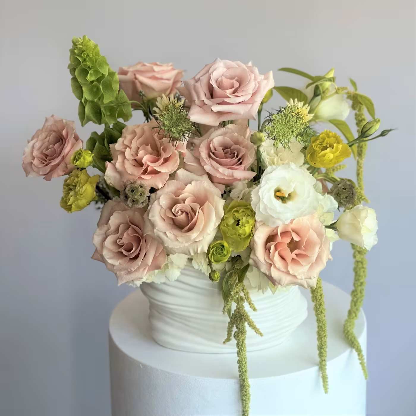 #23 Vibe - Muted tones, graceful curves, and gentle textures come together in Whisper, a one-sided arrangement designed to evoke calm beauty and timeless sophistication. Presented in a clean white ceramic base, it offers a modern and elegant style, perfect for interiors, meaningful moments, or anyone who appreciates  shown an actual size &quot;Deluxe&quot;    Seasonal or not available flowers can be replaced with a similar one. Vases and pots can also be replaced with others