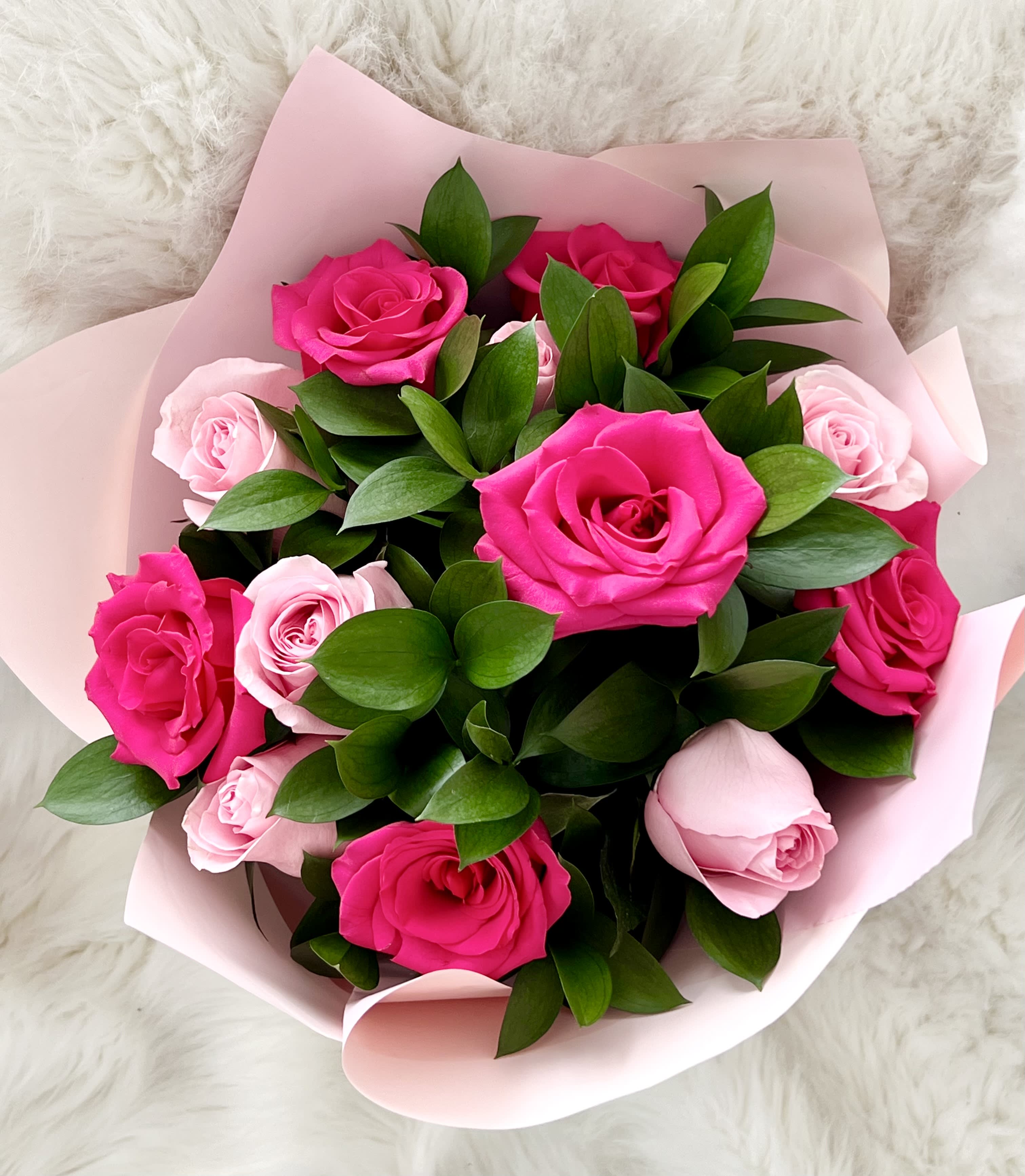 Dozen pink rose bouquet ™ Dozen pink rose bouquet ™ - A romantic bouquet of fresh roses in shades of soft blush and vibrant fuchsia, accented with glossy greenery. Wrapped in pastel pink, it’s an elegant balance of sweetness and passion.