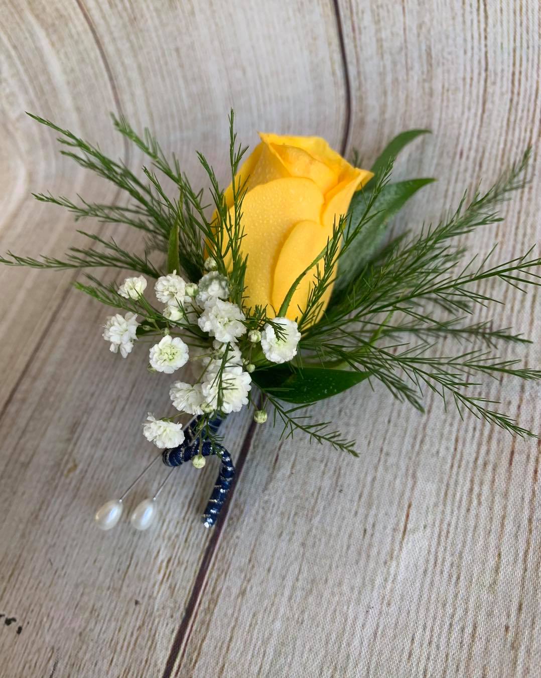 Traditional Rose Boutonniere Traditional Rose Boutonniere - Traditional rose boutonniere with a standard size rose in the color of your choice, with foliage accent, filler, ribbon wrapped stems. ( Standard is a Pin on boutonniere, Deluxe is a magnetic boutonniere) Colors available are Red, Yellow, White / Ivory, Lavender, Orange, and Pink. Please specify color desired in special instructions.