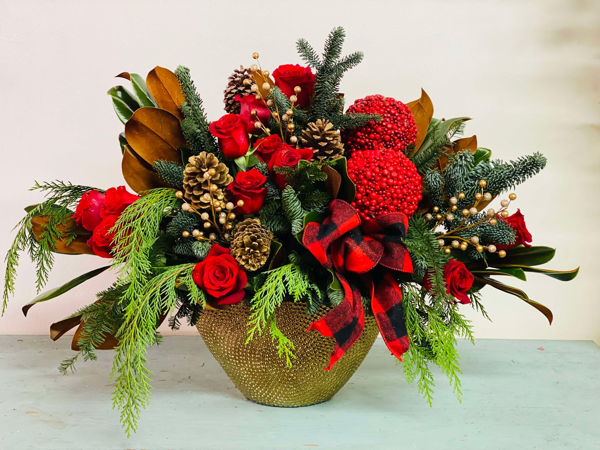 Winter warmth Winter warmth - Experience the rich hues of the holiday season with our "Winter Warmth" floral arrangement. This exquisite design combines deep red roses, magnolia leaves accented with vibrant red berries and lush greenery. The entire composition is thoughtfully arranged in a sleek gold ceramic container, making it a sophisticated choice for holiday decor or a heartfelt gift. "Winter Warmth" is an ideal way to add a touch of luxury and warmth to any space this winter.