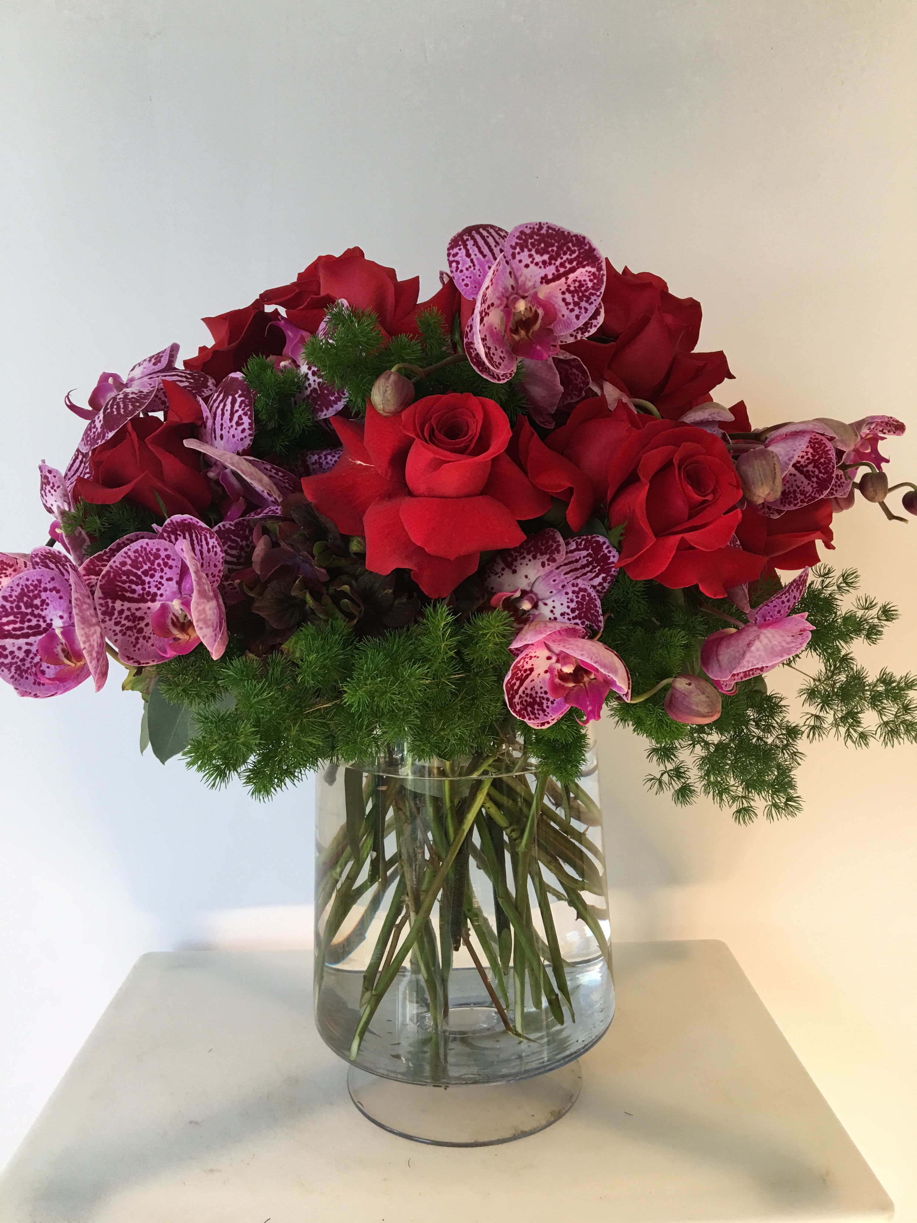 Roses delight  - Nice arrangement with red roses and purple orquids nice arrange in a glass and elegant vase