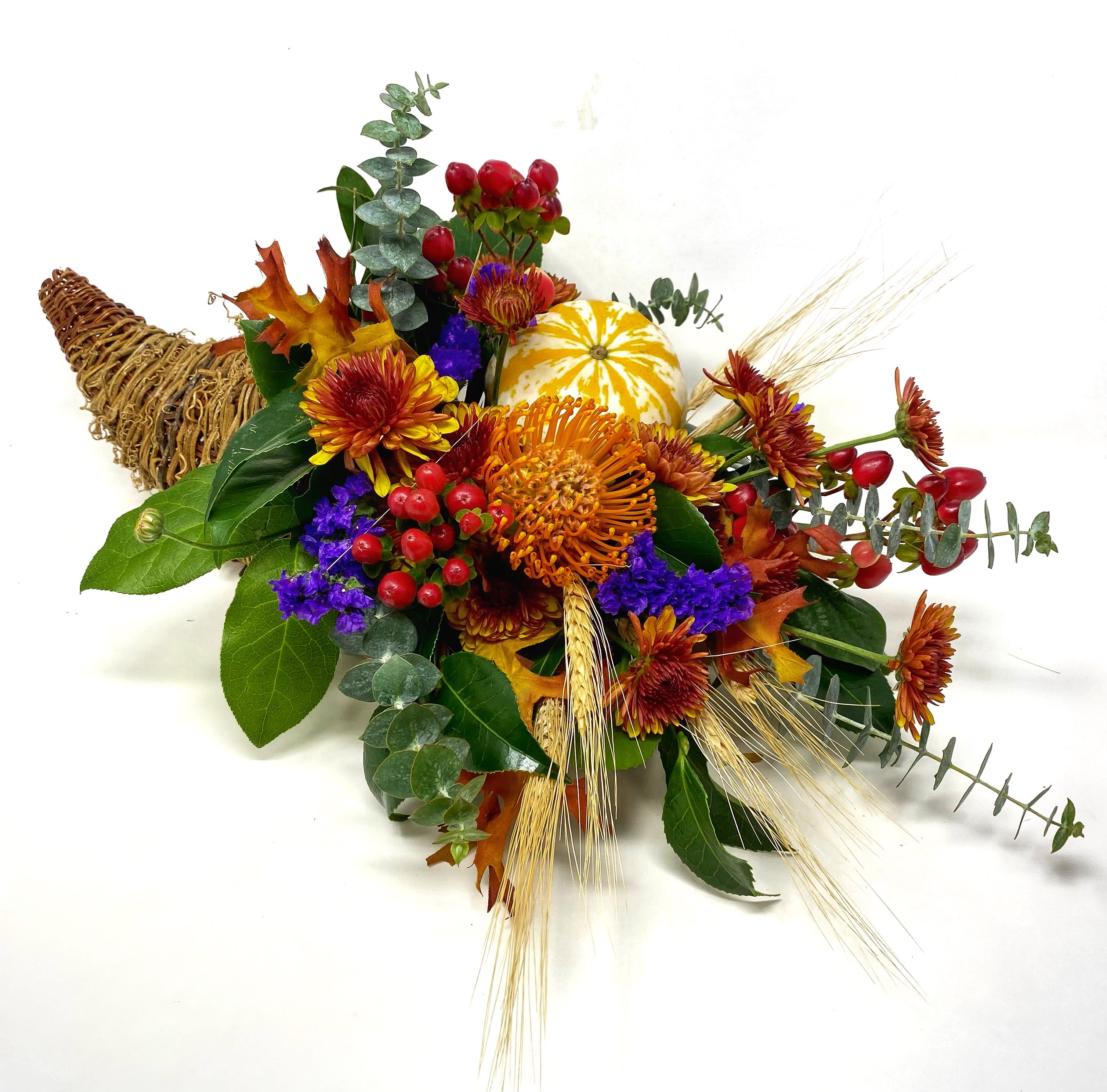 Classic Cornucopia Classic Cornucopia - Nothing says Fall or the Thanksgiving Holiday more than a Cornucopia gracing your dining table. This is filled with a seasonal bounty of hardy blooms and gourds that will be long lasting.
