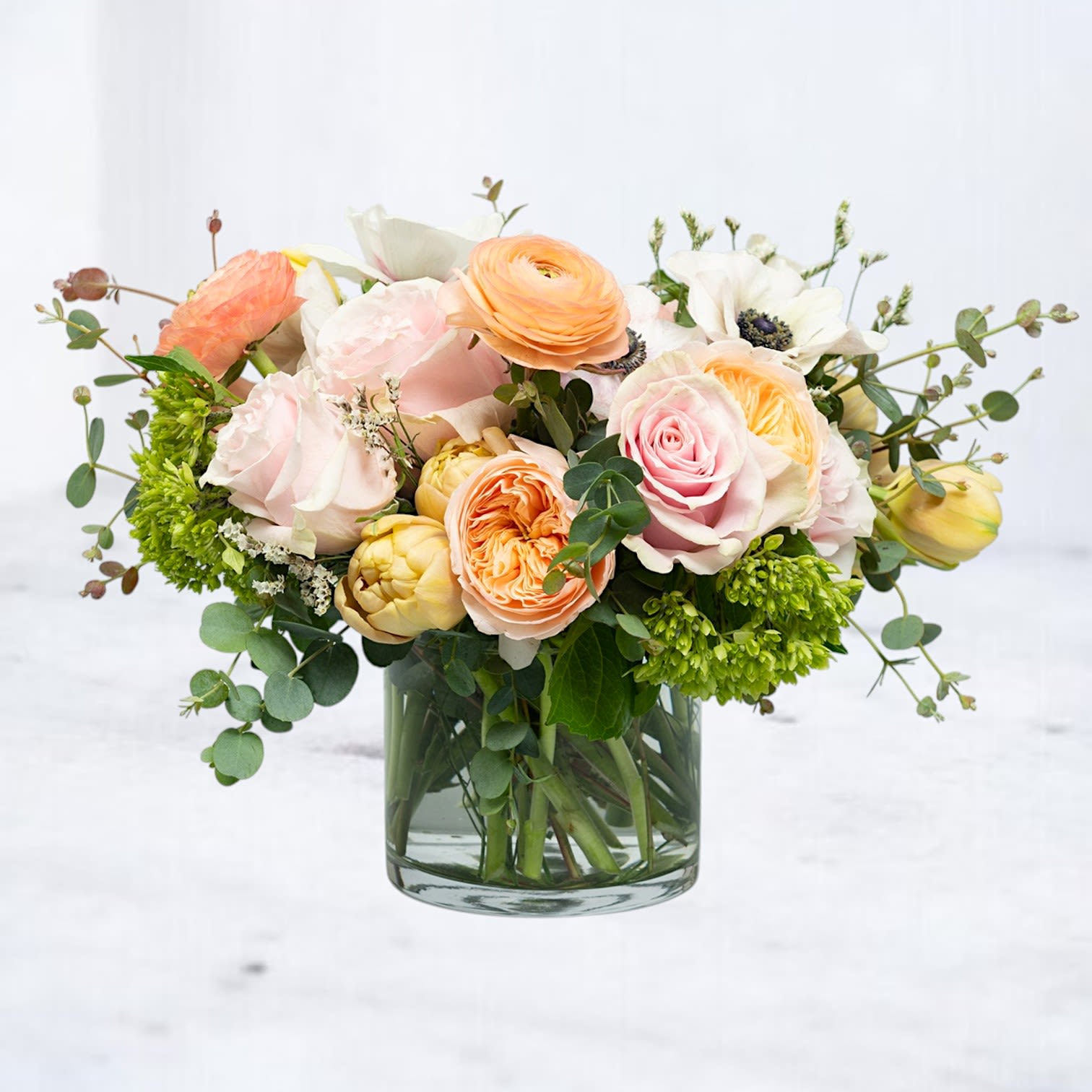Elysian Bloomscape Elysian Bloomscape - Discover the ethereal beauty of the Elysian Bloomscape, a one-of-a-kind floral arrangement crafted to evoke a sense of serenity and splendor. This exquisite design features blush roses, peach ranunculus, yellow tulips, and verdant hydrangeas, delicately arranged with eucalyptus and natural accents for a fresh, organic feel. Ideal for marking life’s special moments or as a luxurious centerpiece, the Elysian Bloomscape brings timeless elegance to any space. With same-day delivery in Houston and nearby areas, your heartfelt sentiments are just a bouquet away.