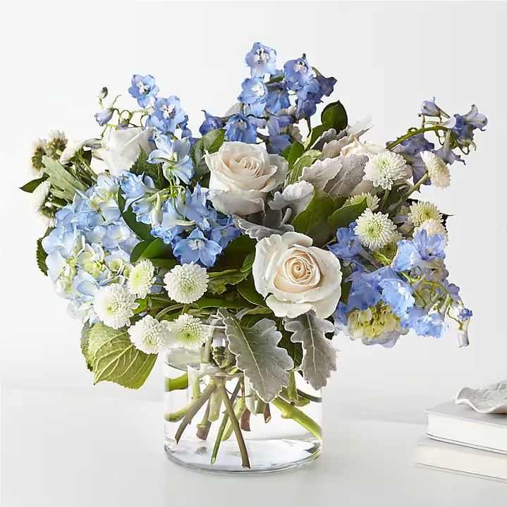 Azul Vase Arrangement - A beautiful in season blooms of white and blue florals designed in a low style vase. 