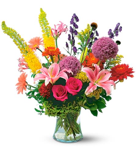  Galore Arrangement  -  A beautiful mix of seasonal flowers such as Roses,  Gerbera , football mums, stargazer lilys, ranaculas, pin cusions,  stock, delphinums, larkspur ect.  A beautiful unique blend of florals surely to bring a smile and a full heart to anyone receiving this beauty.  Our talented designer with put together a one of a kind masterpiece.  Arrangement is delivered in a gorgeous clear glass vase. Approximately 23&quot; W x 34&quot; H Orientation: All-Around As Shown :
