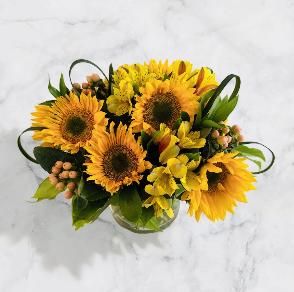 Sunny Days - Send some Sun with a bright sunflower bouquet, accented with alstroemeria, hypericum berries, bear grass &amp; salal. 