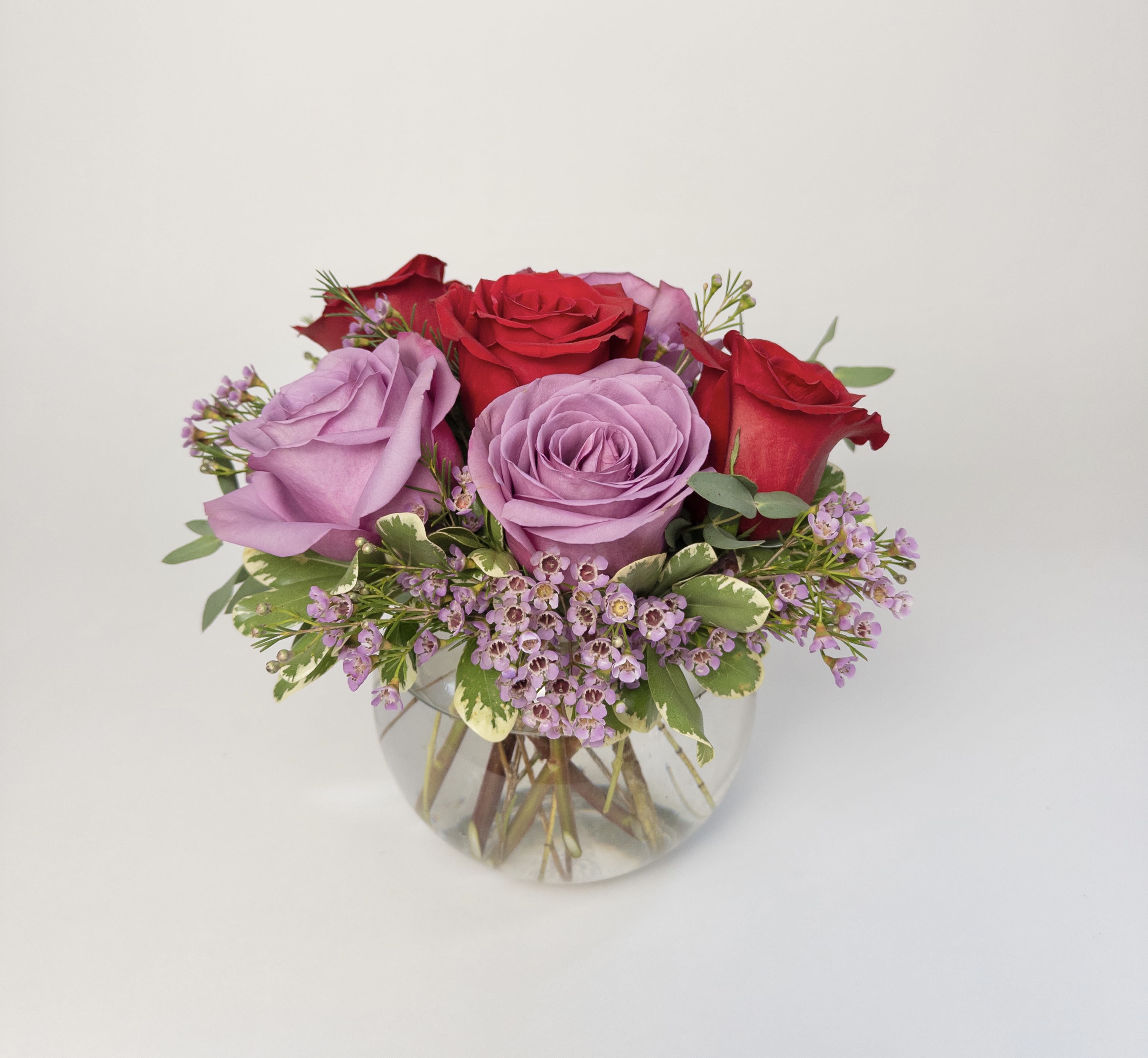 Half dozen rose bowl  - A clear glass bubble bowl filled with 6 roses and lavender waxflower. The picture shown is half red/half lavender but other colors are available upon request! 