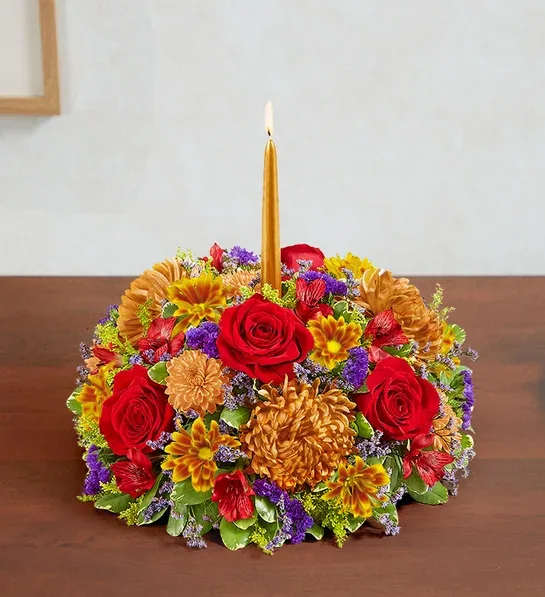  Autumn Centerpiece - Set the table in brilliant style. Our new centerpiece captures the rich beauty of autumn in every last detail. Pops of red and bronze mix with lush greens. A gold tapered candle stands at the center, creating a warm and cozy ambiance for every gathering.