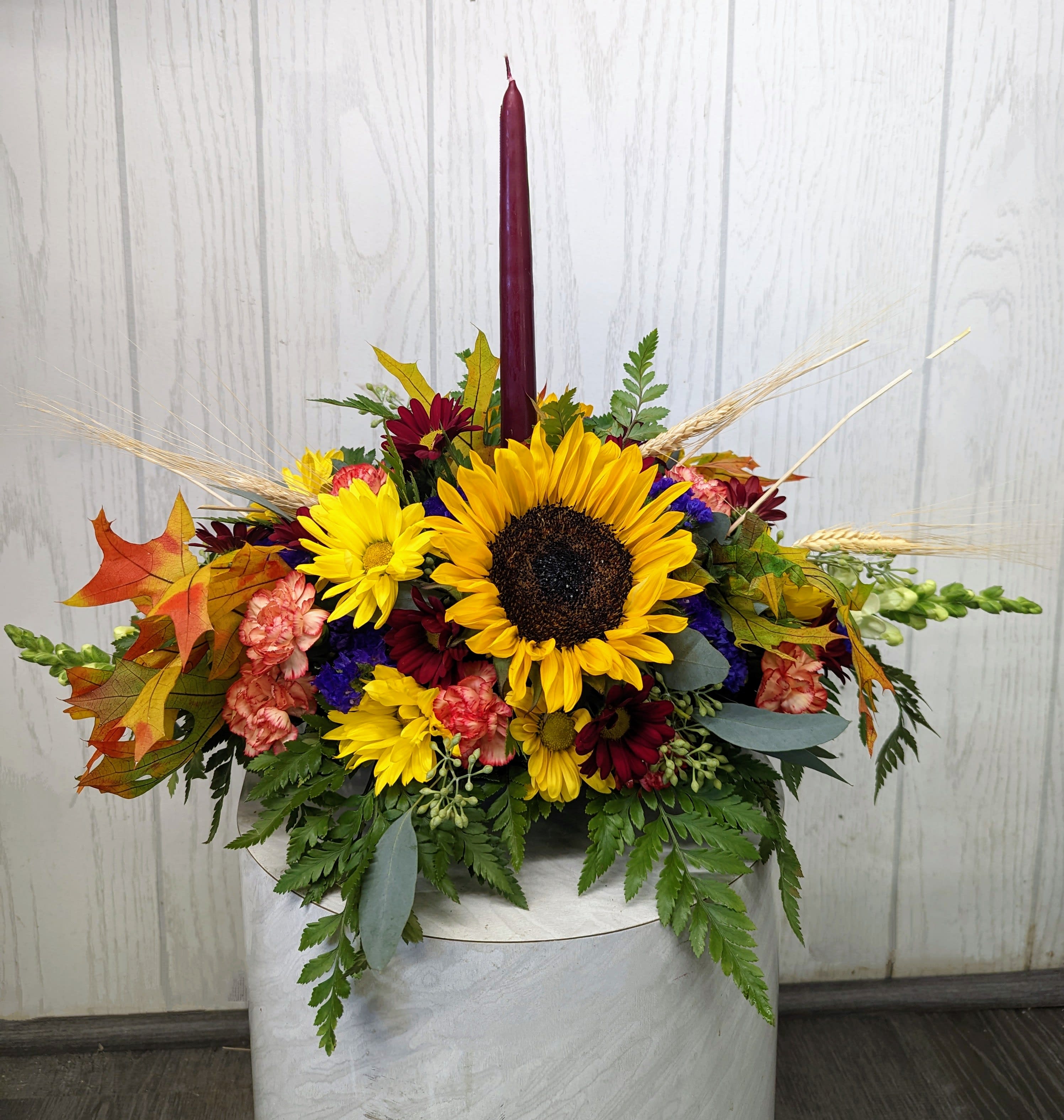 Single Candle Fall Centerpiece Single Candle Fall Centerpiece - This traditional candle centerpiece is perfect for celebrating Thanksgiving. Approx. 15 inches long. Deluxe & premium include more flowers. ***FLOWER SUBSTITUTIONS/DESIGNER’S CHOICE*** The flowers may be substituted, but the beauty and price value will be maintained.