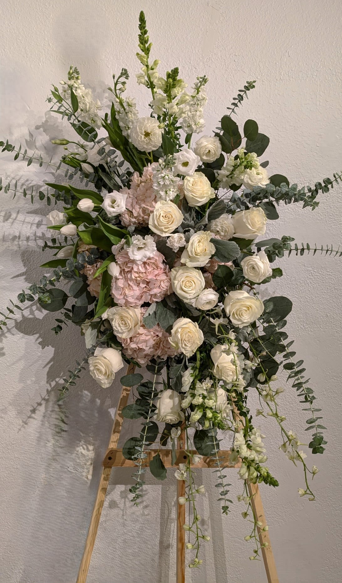Elegance in Pink - This standing spray blends soft pinks and true white, creating a serene and timeless expression of love and remembrance. 