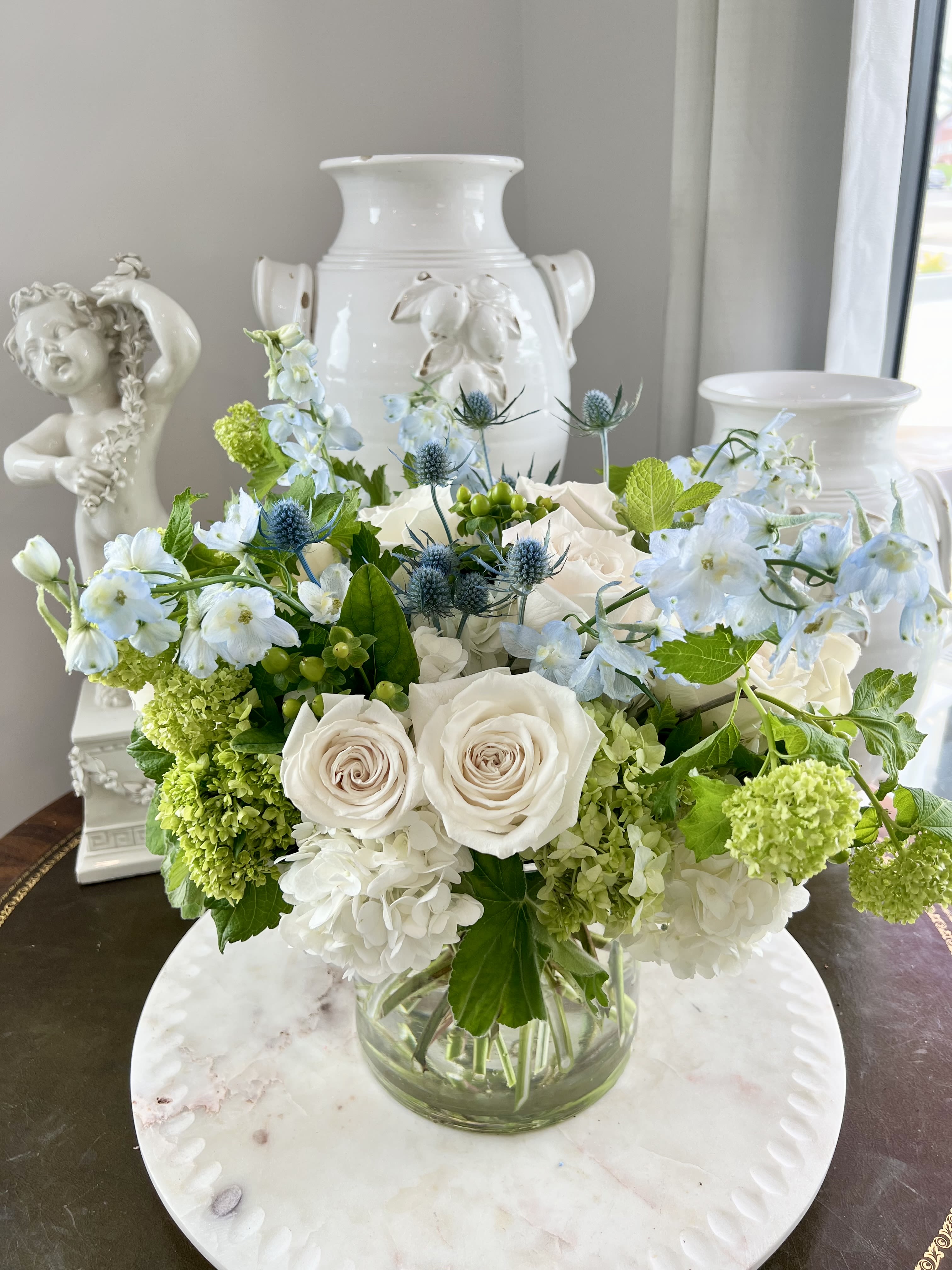 Springtime Blue - This is a classic mix of the best of the spring season. Green viburnum, white hydrangea, baby blue delphinium, polo roses, and thistle with a touch of fresh mint to tantalize all your senses.