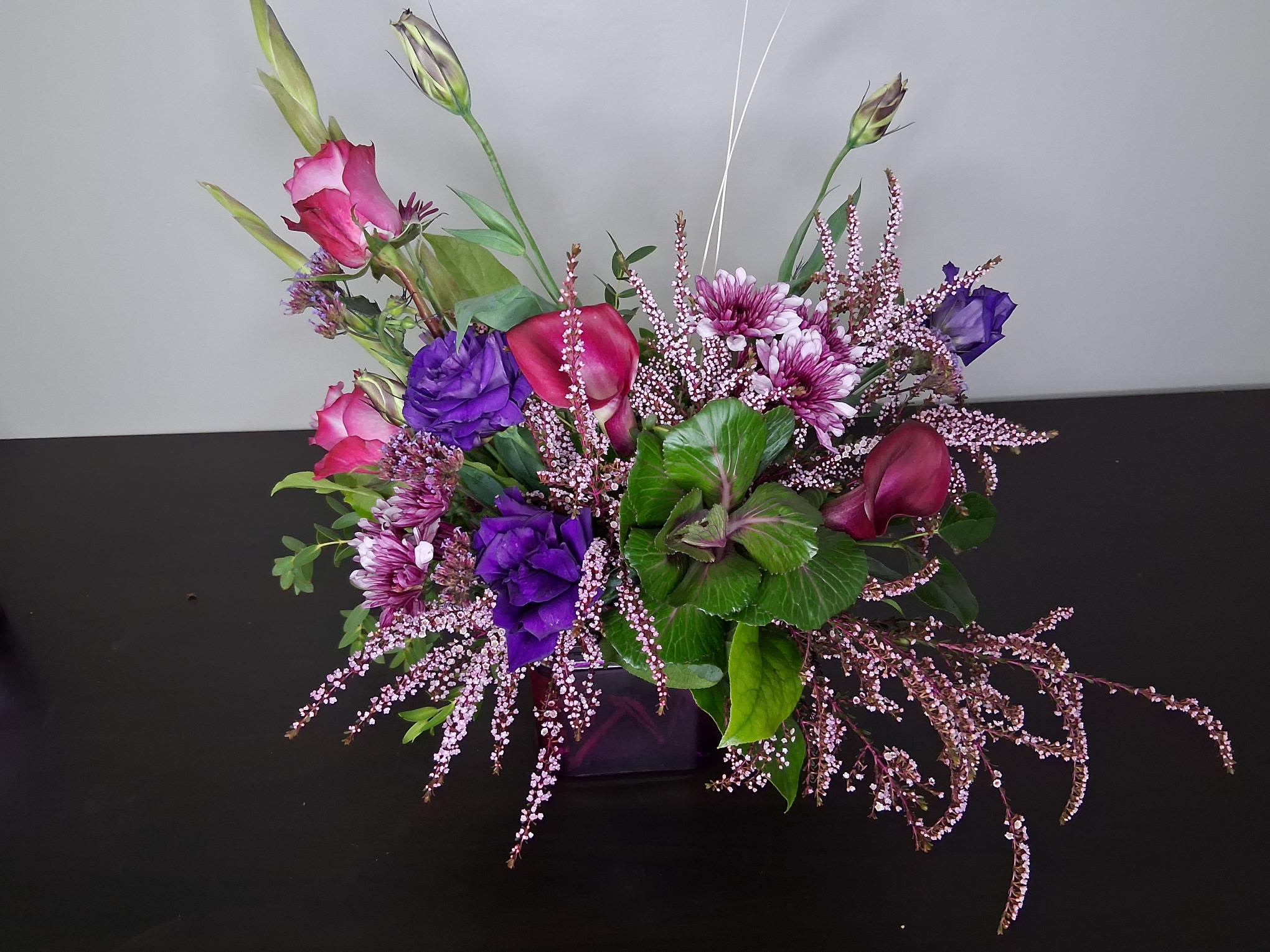 Purple Passion  - Designed with the deep purple glass cube as inspiration, the rich hues and varying shades add depth  while the kale and filler add texture and movement. 