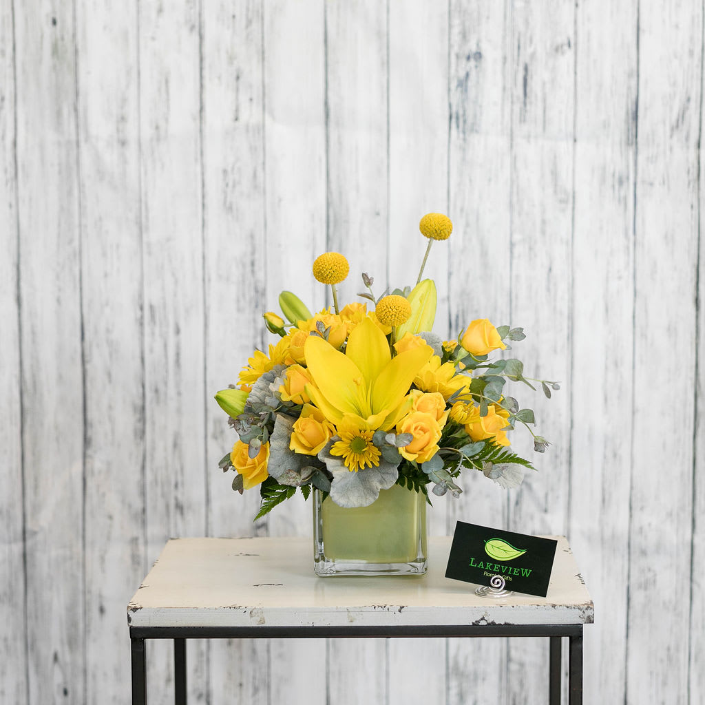 Lemondrop - Sunshine in a vase!  Bright yellow blooms including lilies are sure to put a smile on anyone's face!  This compact arrangement is perfect to adorn a desk or coffee table!  Approximate Dimensions: 12&quot; H x 9&quot; W
