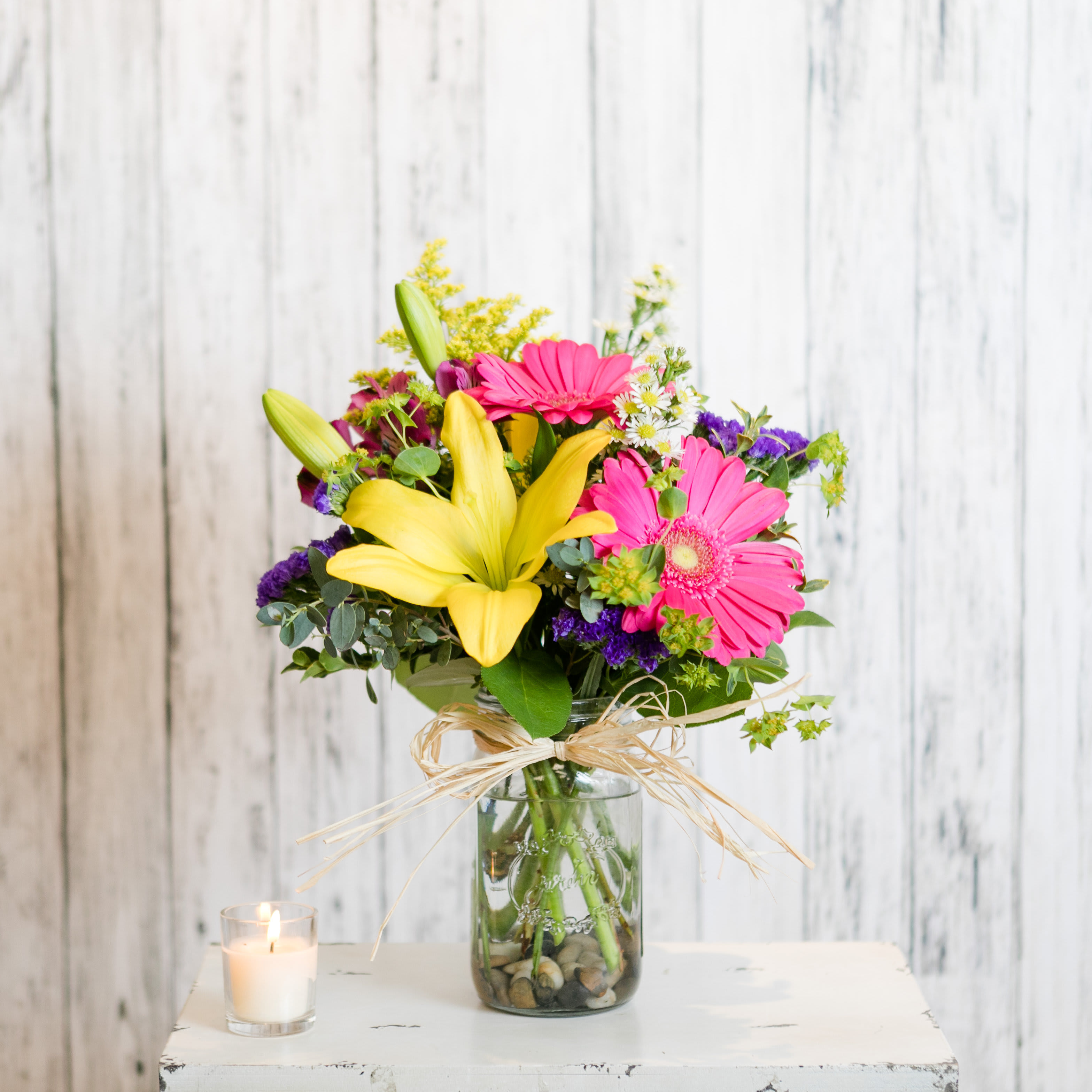 Market - Reminiscent of a summertime farmer's market bouquet a mason jar holds bright blooms accented by a raffia bow.  Approximate Dimensions: 16&quot; H x 9&quot; W