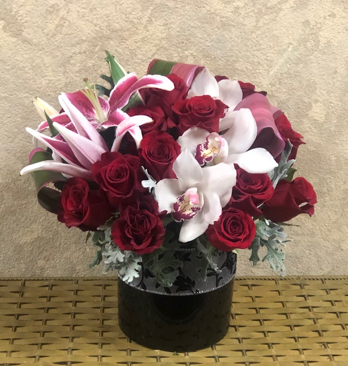 Truly Madly Deeply Truly Madly Deeply - Perfect for Valentine's Day, Love and Romance, Anniversary. Type of Flowers: Stargazers, White Cymbidium Orchids, Red Roses, Tropical Leaves, and Dusty Miller in a short, black vase with ribbon. Availability: All year round Substitute Available: Yes Design View: All Facing View Photo shown: Regular