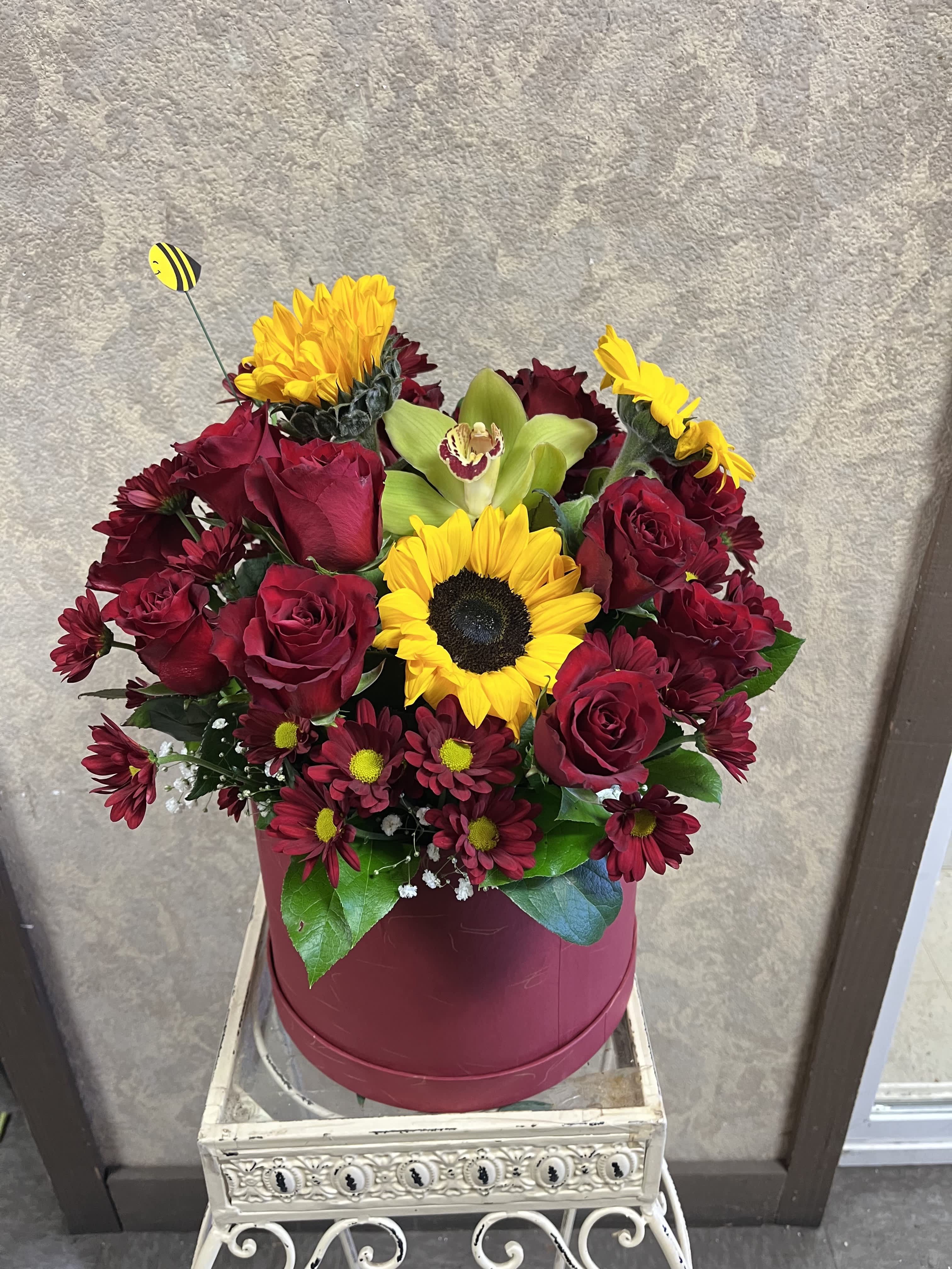 Honey Bee Honey Bee - Recipe: Red Roses, Red Daisies, Sunflowers and Green Cymbidium Orchids in a big, red box. Availability: All year round Design View: All Facing View Photo shown: Standard