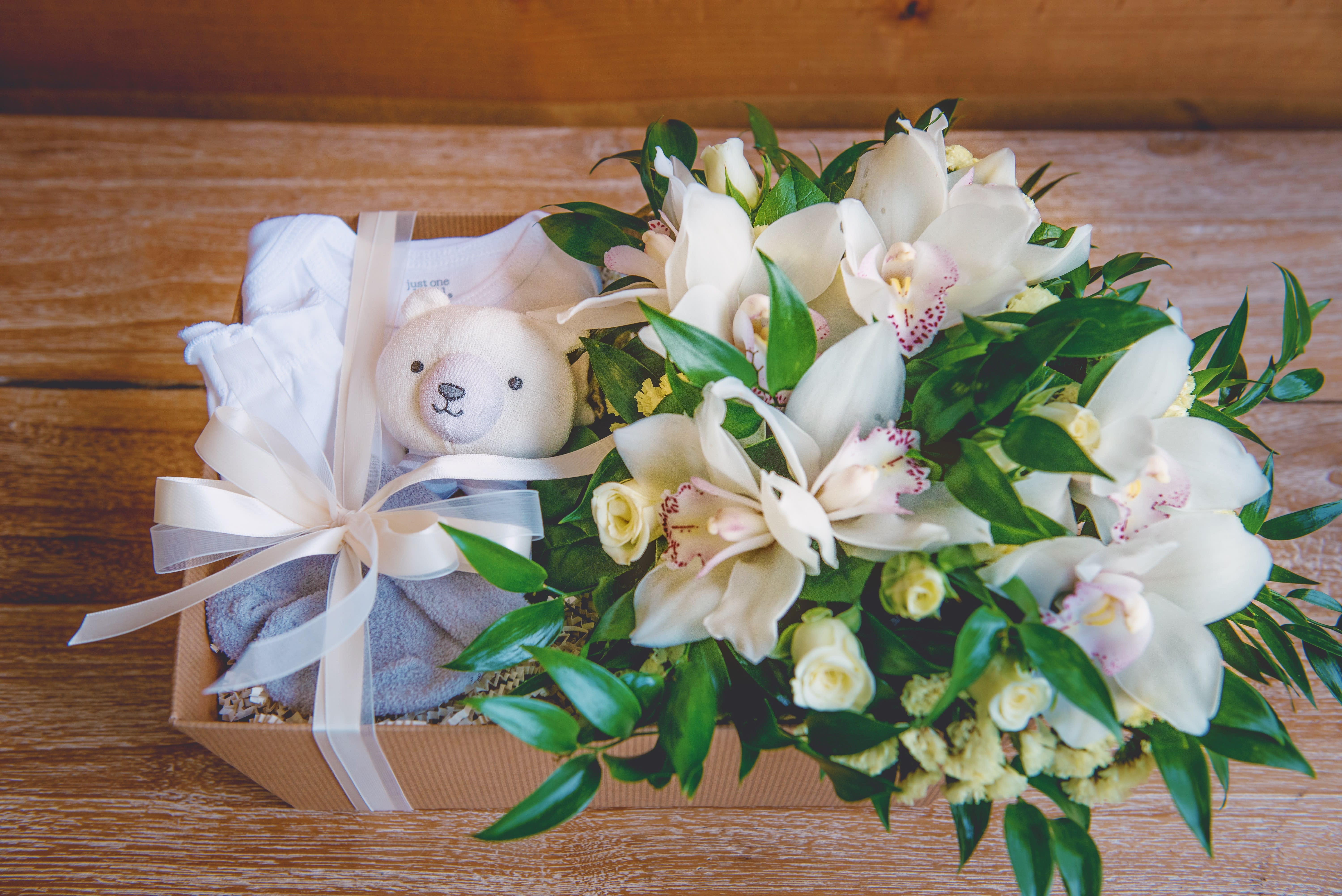 Welcome Baby! Gift Box - Welcome Baby! The perfect gift for any new mom, curated with love.  Inside: -Fresh flower bouquet (designers choice)  -White baby onesie  -Soft Rattle  -Socks   -Hand Mittens *Flowers may vary according to availability to ensure fresh quality flowers 