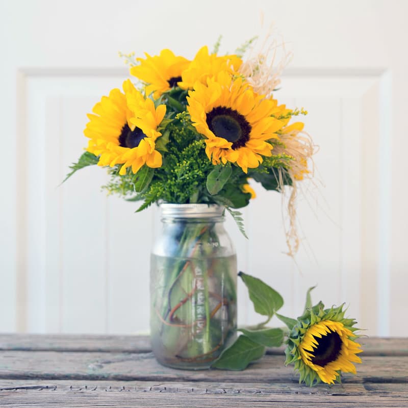 Sunny Sunflowers Sunny Sunflowers - Sunflowers in a mason jar with yellow, white or purple accents.