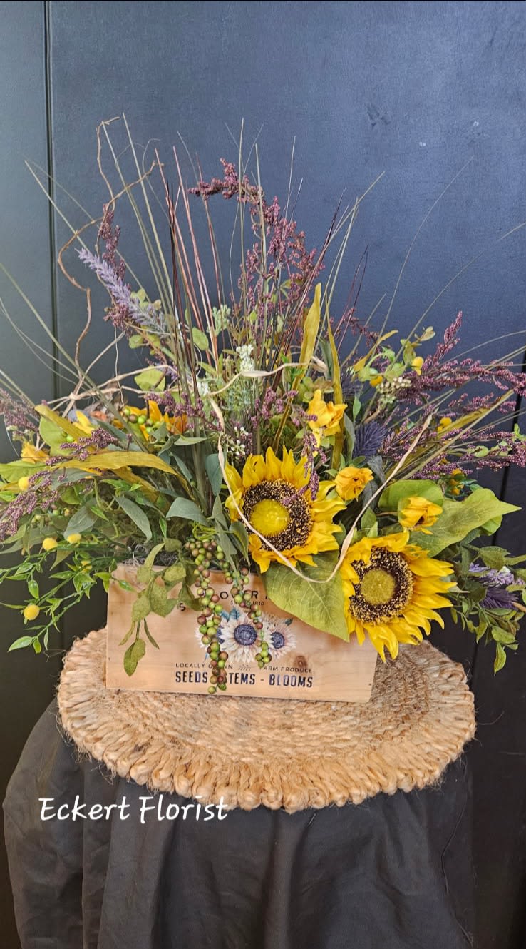 Eckert Florist's Artificial Sunflower Box Bouquet *Our Local Delivery Only Eckert Florist's Artificial Sunflower Box Bouquet *Our Local Delivery Only - Designed in a wooden box, this charming country artificial arrangement features sunflowers amongst other wispy florals and greenery. Measures approx. 17" High x 25" Wide *Our local delivery only