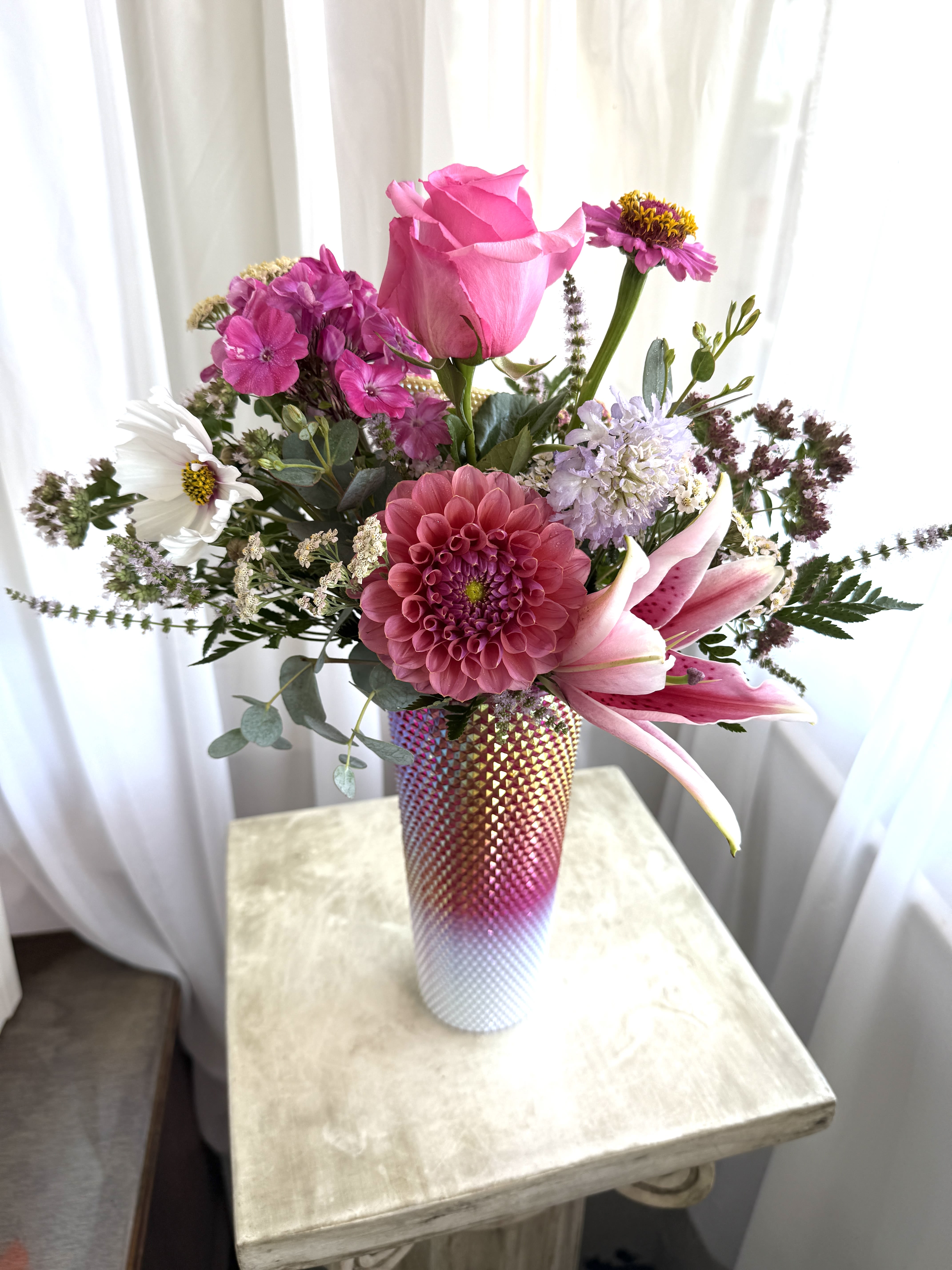 Pink Tumbler Pink Tumbler - A reusable drink container holds seasonal blooms. Two gifts in one! As always, substitutions may happen because our stock constantly changes. Call shop with questions.
