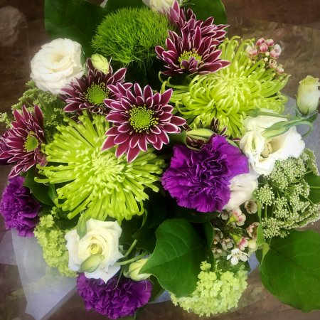 Hand-Tied Bouquet #2 Hand-Tied Bouquet #2 - Bold and refreshing, this striking arrangement features lime green spider mums and greenball dianthus paired with rich purple carnations and bi-color chrysanthemums. Creamy white lisianthus and delicate filler flowers add a soft contrast, while lush greenery ties it all together for a bouquet full of personality and flair.