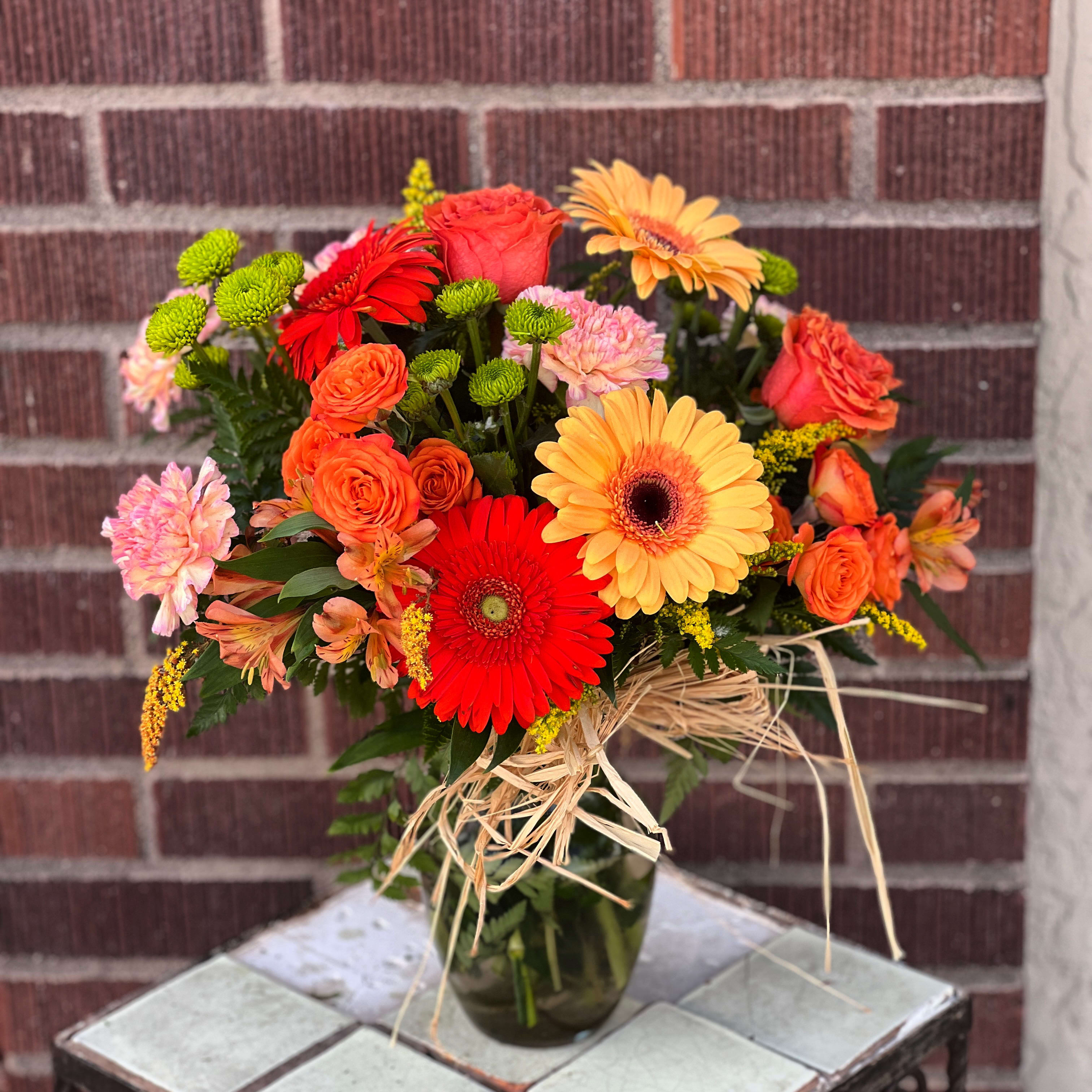 Fall Party - Designed by one of our local gals, featuring gerbera daiseis, roses, spray roses and button chrysanthemums with raffia.