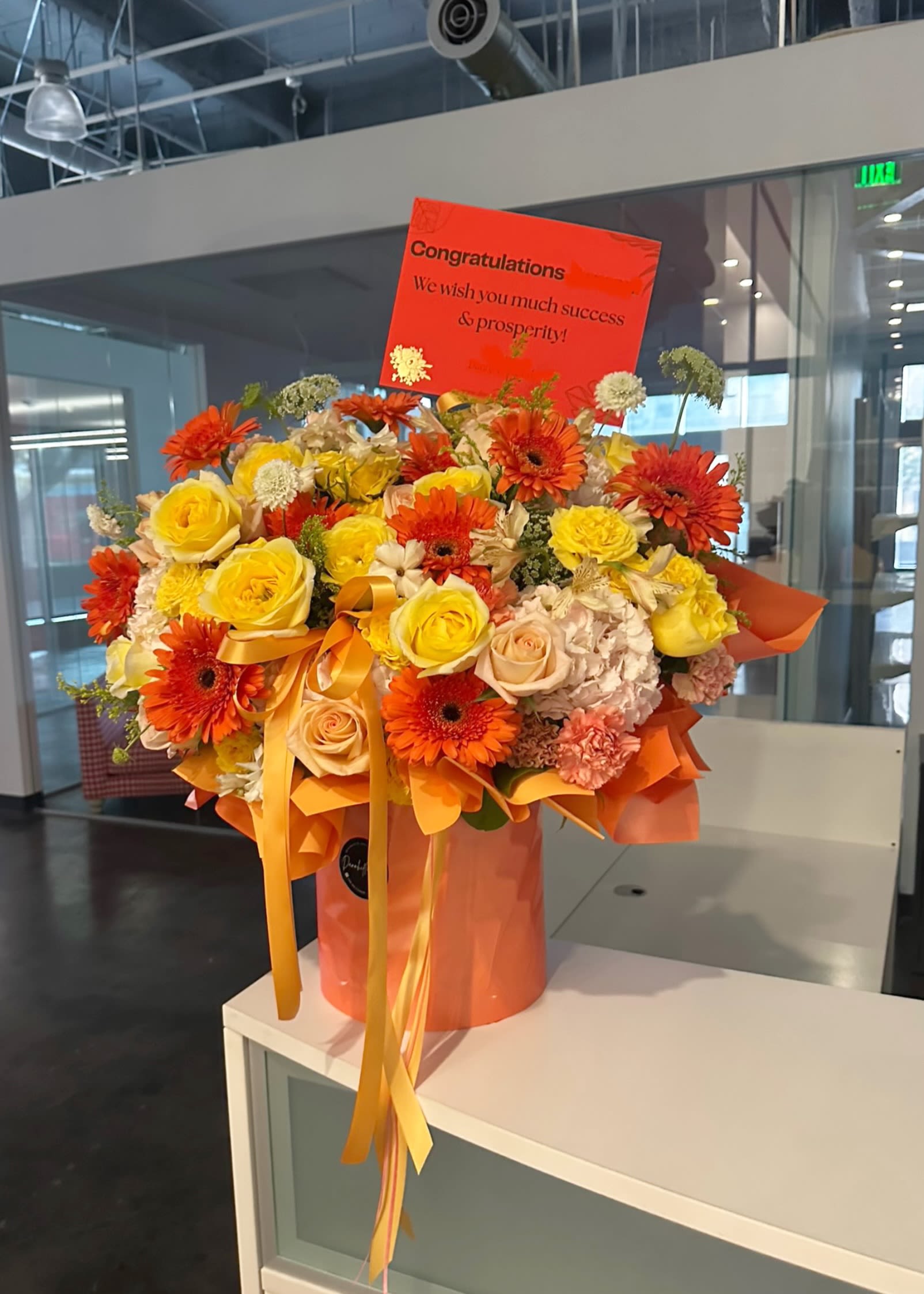 Prosperity Blooms Prosperity Blooms - A radiant box of vibrant orange and yellow blooms, symbolizing joy, success, and new beginnings, perfect for congratulations, business openings, and life’s brightest celebrations. Card message is included.