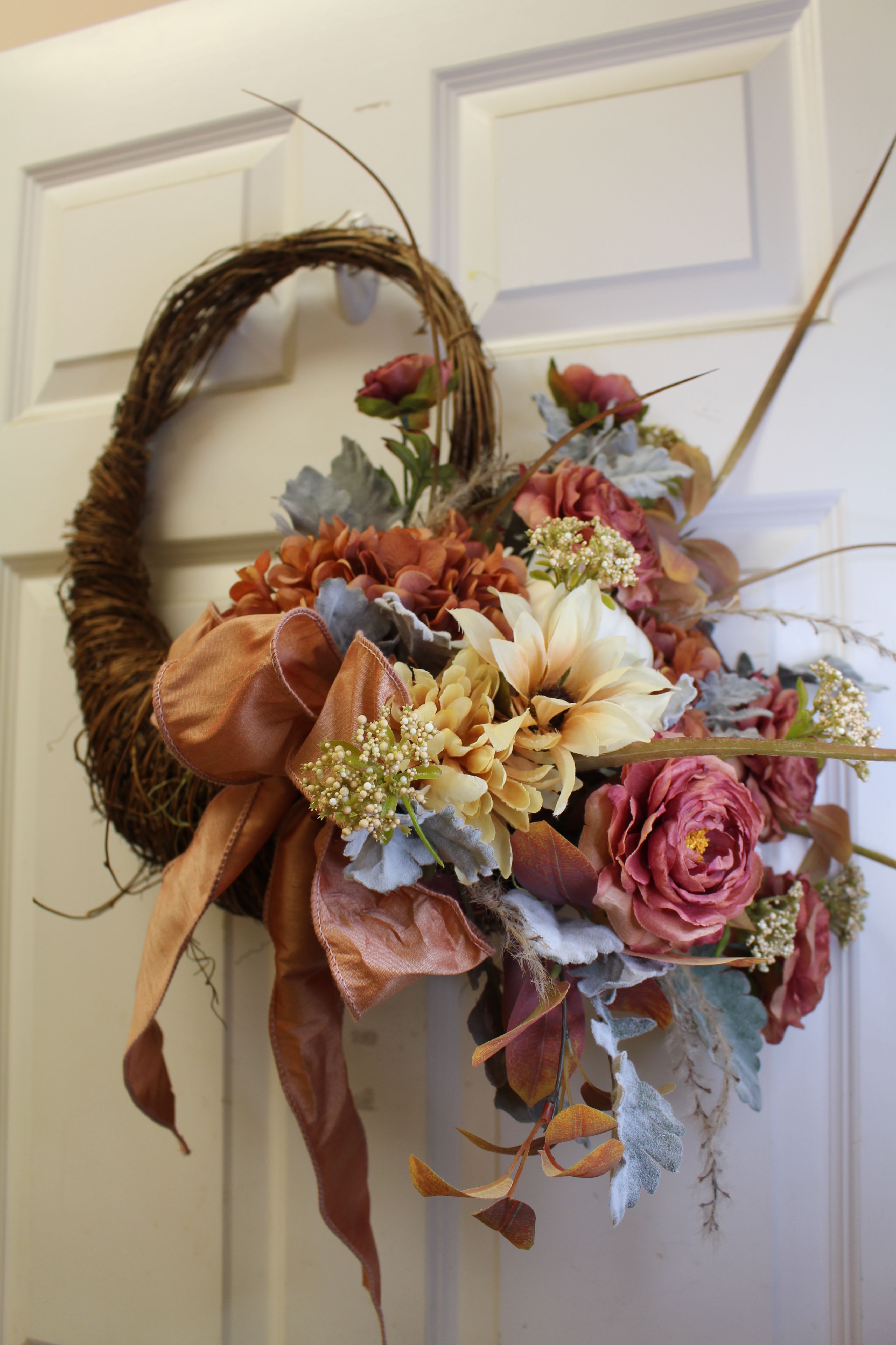modern cornucopia  - a permanent piece that can be taken out year after year.  A modern twist on autumn, Sage, coppers and terra cotta flowers fill this wreath