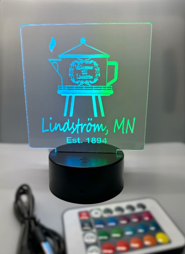 LED Lindstrom Watertower - Illuminate your space with this vibrant LED Lindstrom Watertower featuring a 16-color LED base. Powered by 3 AA batteries (not included) or conveniently via the included USB cable, this decorative piece offers versatile lighting options.   Customize your display by selecting individual colors or opt for an automatic color cycle. Adjust brightness and speed easily through controls on the base or via the remote control powered by 2 AAA batteries (not included).  Enjoy four dynamic lighting modes—fade, flash, strobe, and smooth—across seven color options for a captivating visual experience.  USB Cable &amp; Remote Control included, batteries not included.  This item measures 7 inches tall by 5 inches wide. 