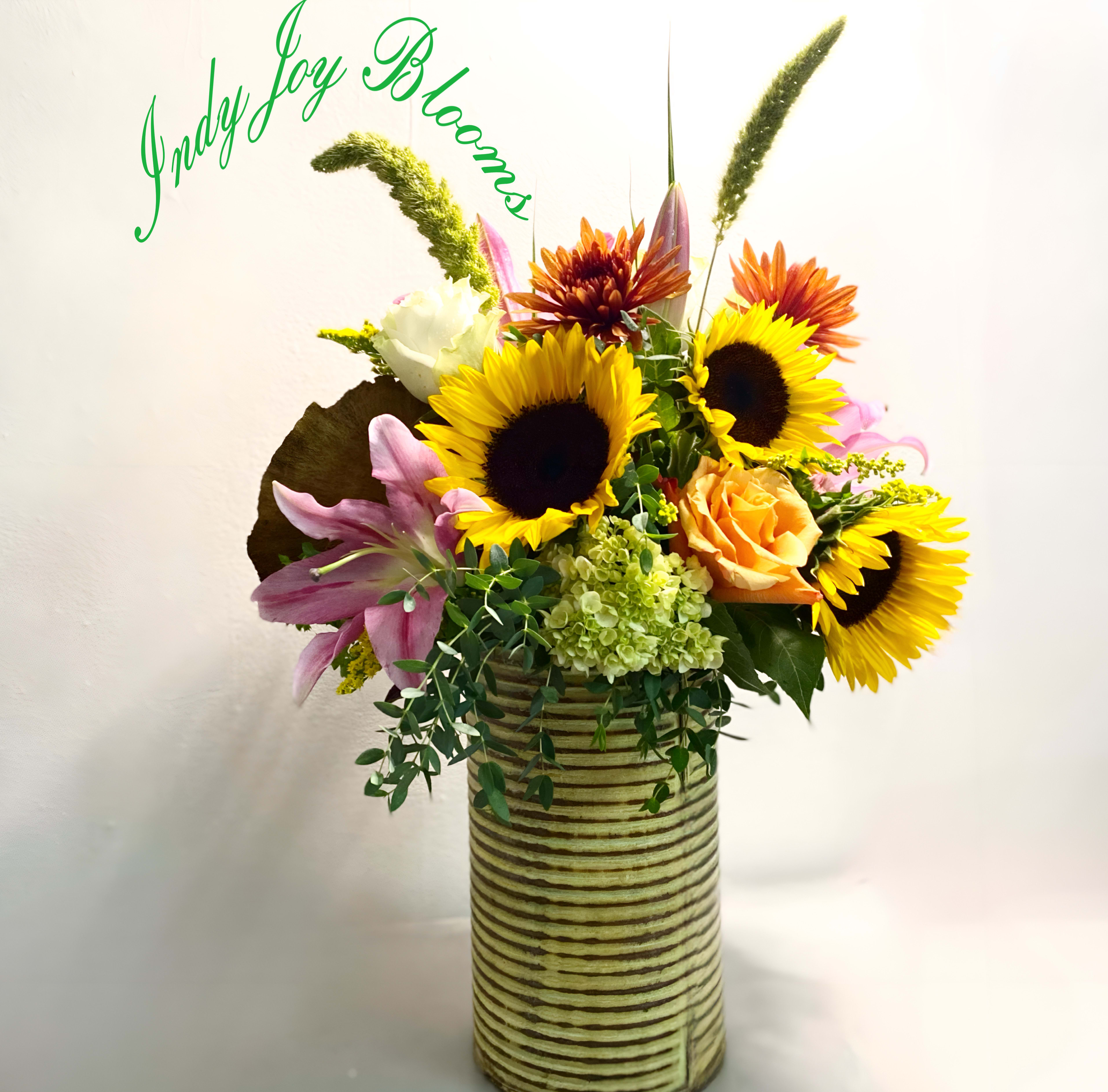 A fall feeling bouquet - Want to send a gift to say thinking of you, get well, thank you or happy birthday? A fall feeling has wild grasses, sunflowers, hints of green, orange and white in a rustic container. This is a law fairly large piece that will defiantly leave a smile on your persons face.   Containers may change upon availability and will be substituted as needed with same value,size and rustic look. We also substitute some flowers depending on the freshest of the day. 