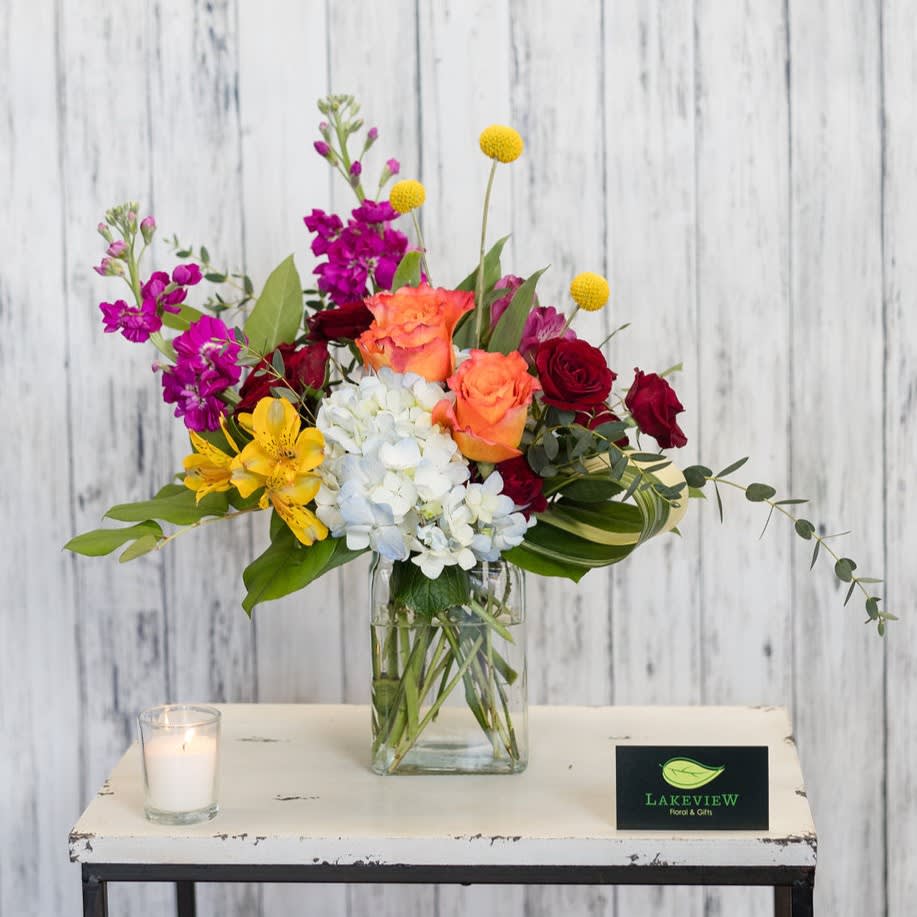 Lively - Sure to cause a stir, this modern arrangement of bright blooms includes hydrangea, craspedia, stock and roses.  Approximate Dimension: 16&quot; W x 13&quot; H
