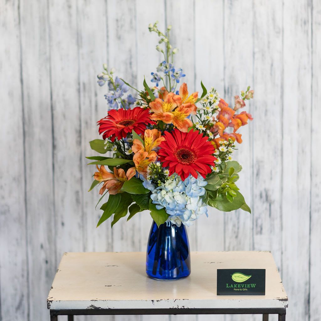 Sultry - Vibrant shades of blues, oranges, and reds are accented by a modern blue vase. Perfect for a desk, countertop, or kitchen table. Sure to make anyone smile!  Approximate Dimensions: 17&quot; H x 9&quot; W