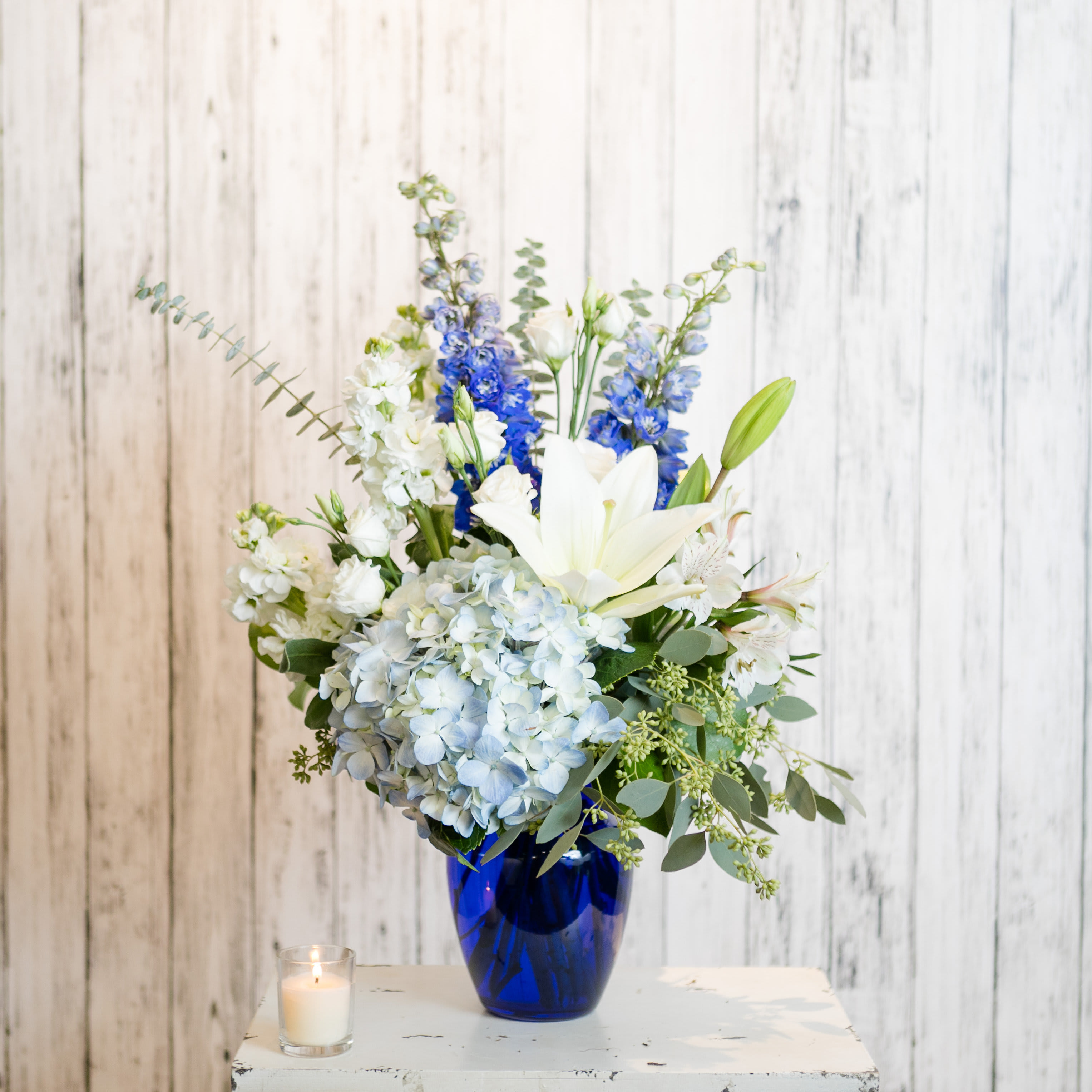 Comfort - Classic blue and white blooms are presented in a cobalt vase.  Versatile and timeless!  Approx: 24&quot; H x 14&quot; W