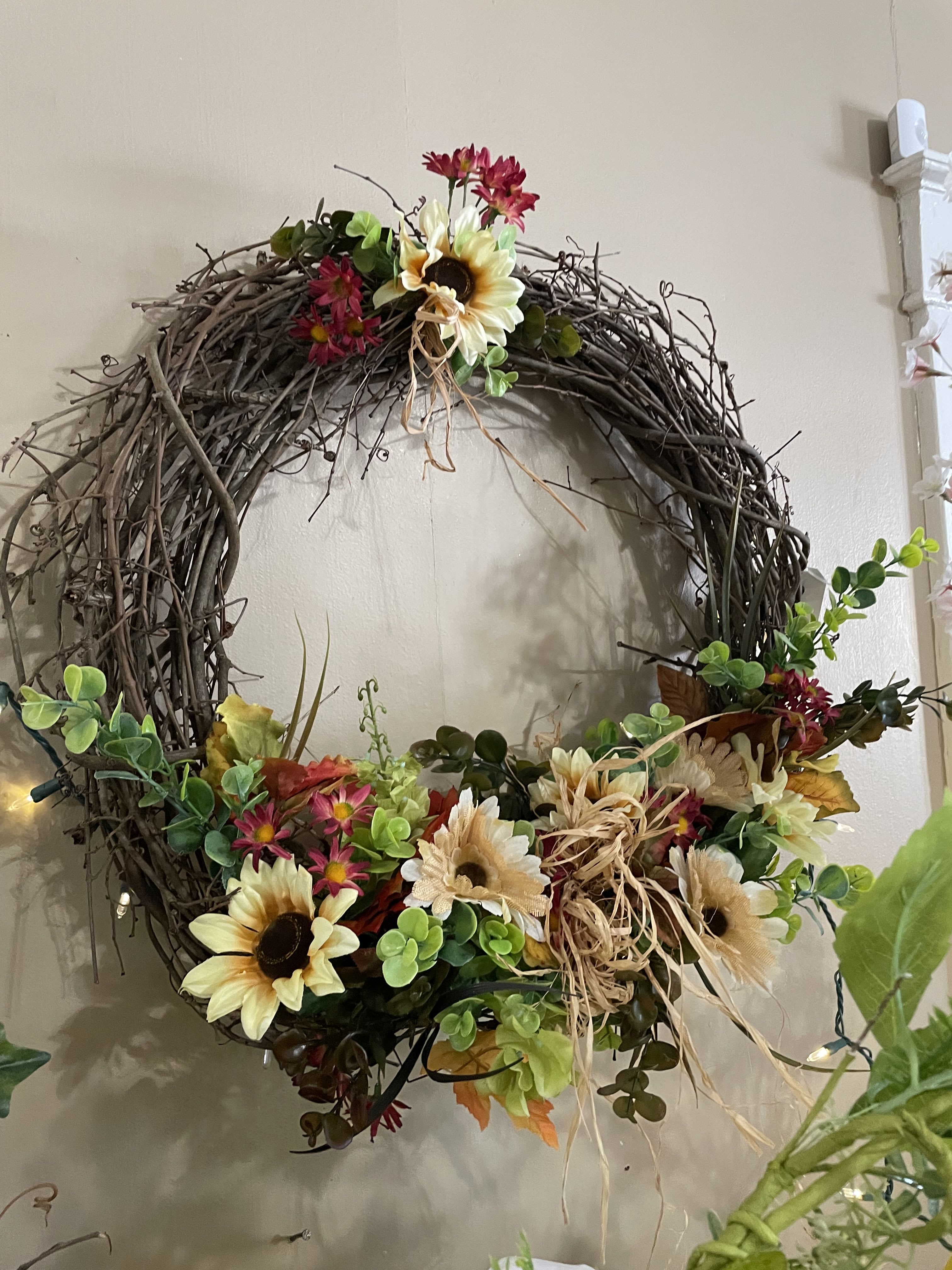 BlRustic Raffia Silk Grapevine Wreath BlRustic Raffia Silk Grapevine Wreath - A grapevine wreath covered in various shades of cream, peach silk flowers, mixed ribbon and green ivy vines and raffia.