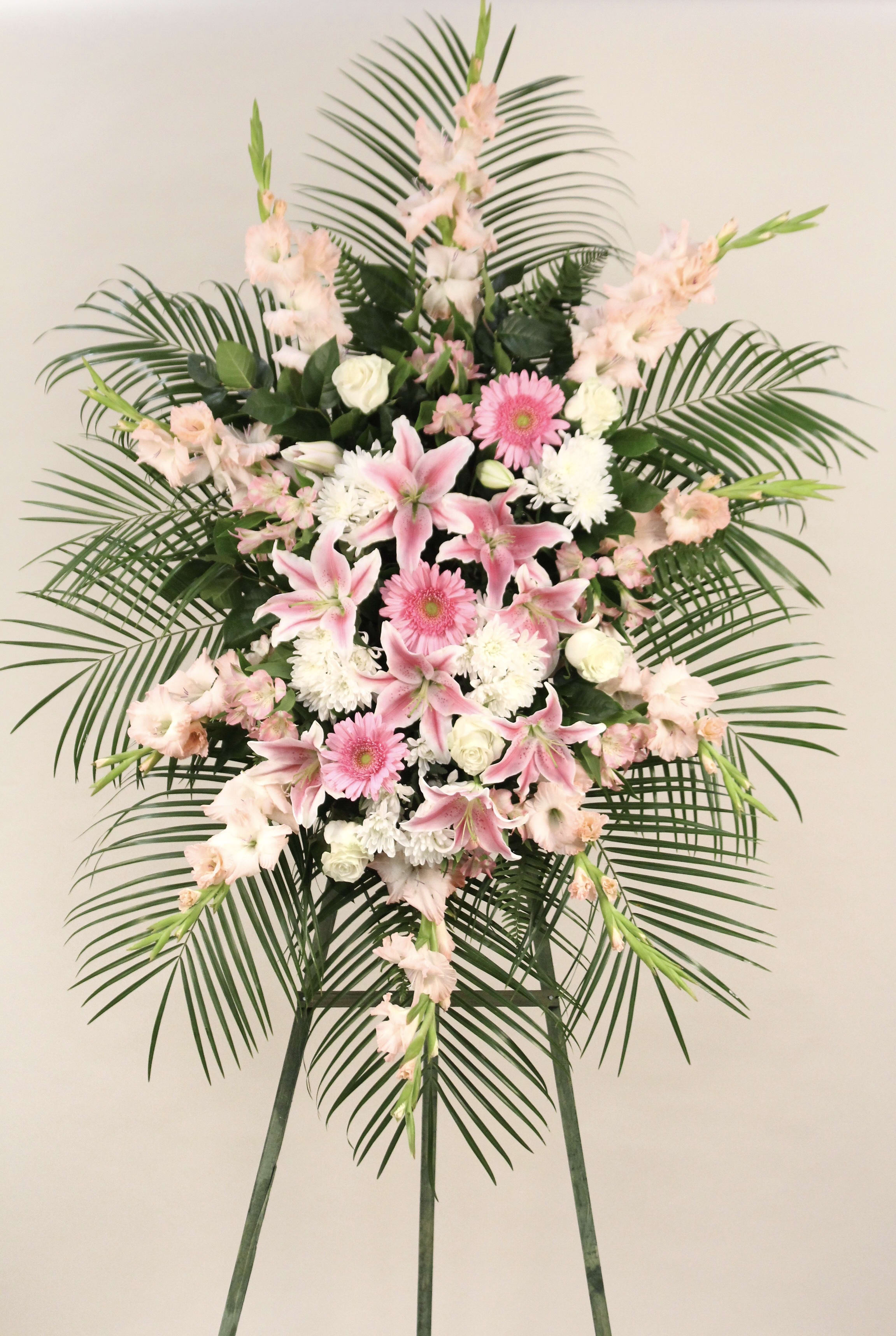 Pink and White Funeral Spray - Express deep condolences and strong hopes for the future with an elegant tribute that conveys admiration, affection, and respect.  Mix of pink and white flowers, may include roses, lilies, gladiolus, gerber daisies, cushion pom pom, alstromeria, and palm leaves.  Easel Stand Height: 5 1/2 ft. - 6 ft.   Approx. Size: 6 ft. H x 28&quot; W  Mix of pink and white funeral spray in a 6 ft easel stand