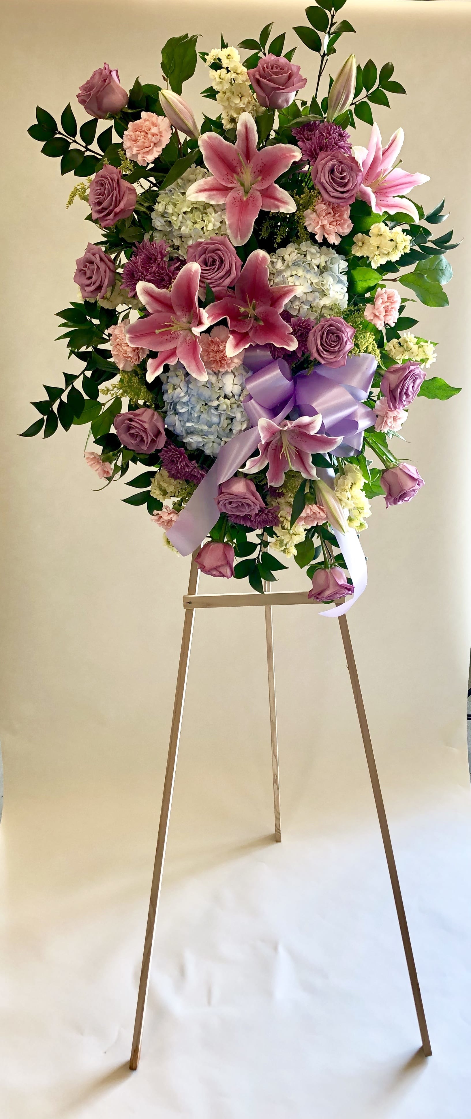 Spring Tribute Funeral Spray - Express deep condolences and strong hopes for the future with an elegant tribute that conveys admiration, affection, and respect.  Flowers may include roses, hydrangeas, lilies, stock, solidago, carnation and greenery. Easel Stand Height: 5 1/2 ft.  Approx. Size: 6 ft. H x 24&quot; W